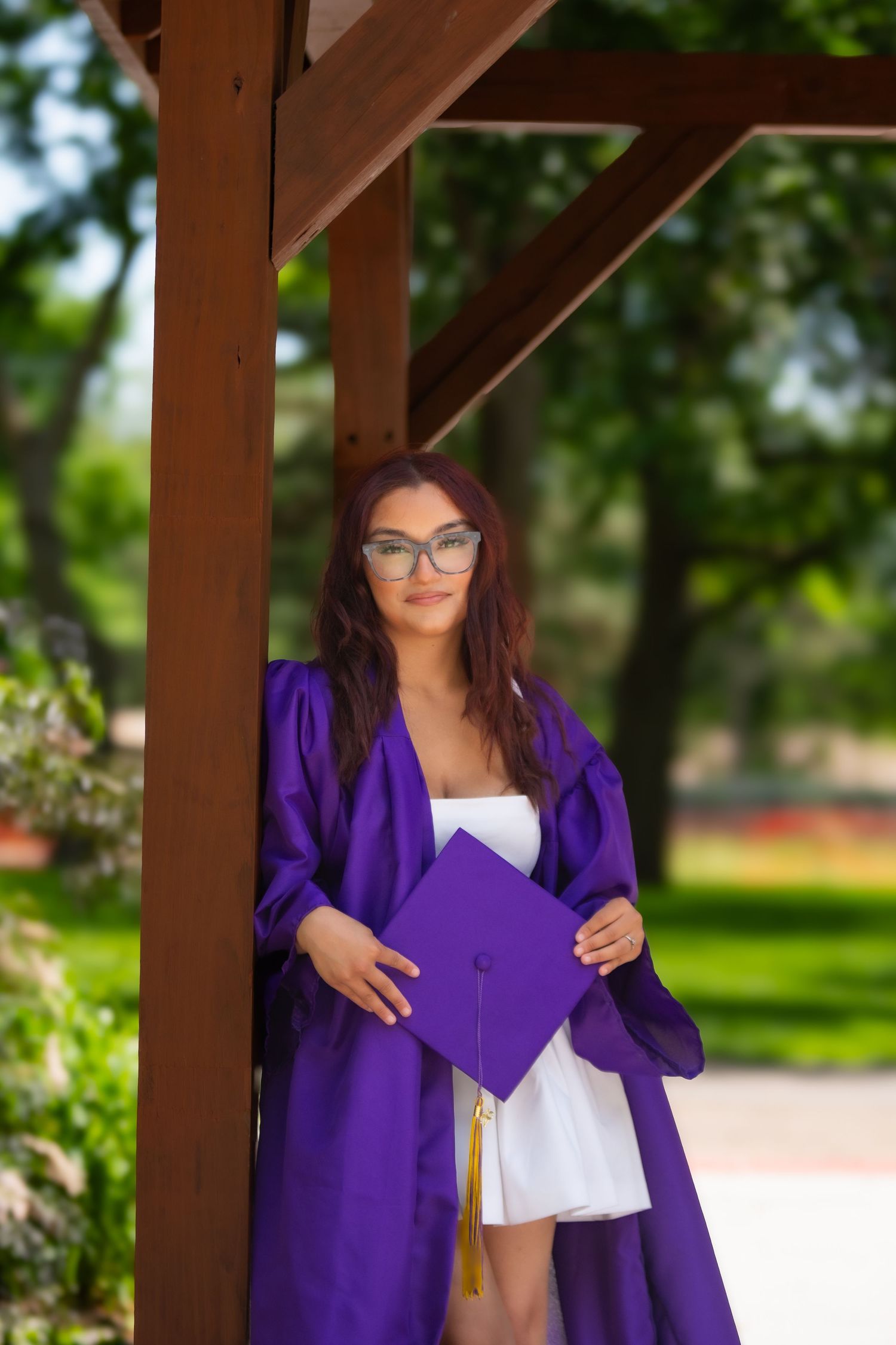 High school senior in purple graduation gown holding her purple cap in Grand Island, Nebraska.