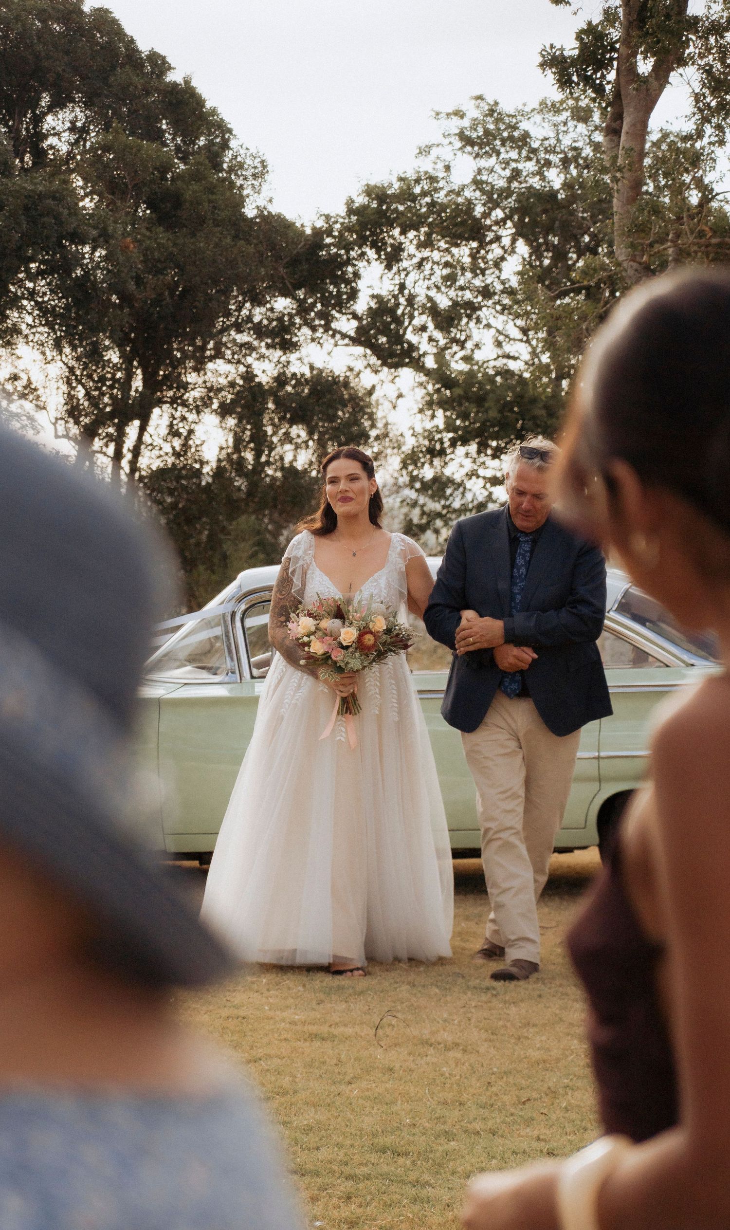Bride walking down the aisle from arrival car at Maroon Hill Estate April Weddings in South East QLD - Wedding photographer Shae Imagery