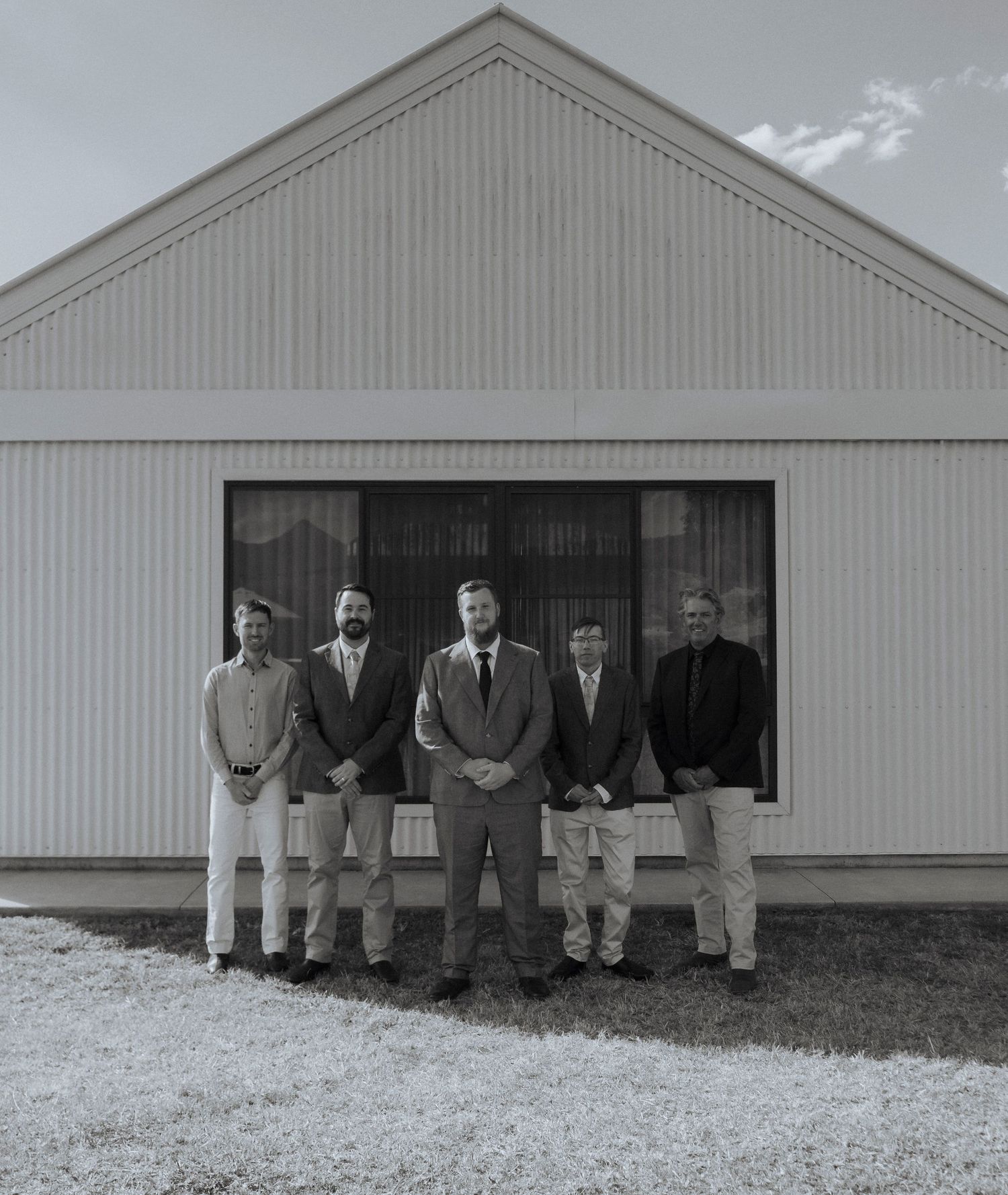 groom and groomsmen captured outside the modern farmhouse architecture at Maroon Hill Estate. editorial wedding photography