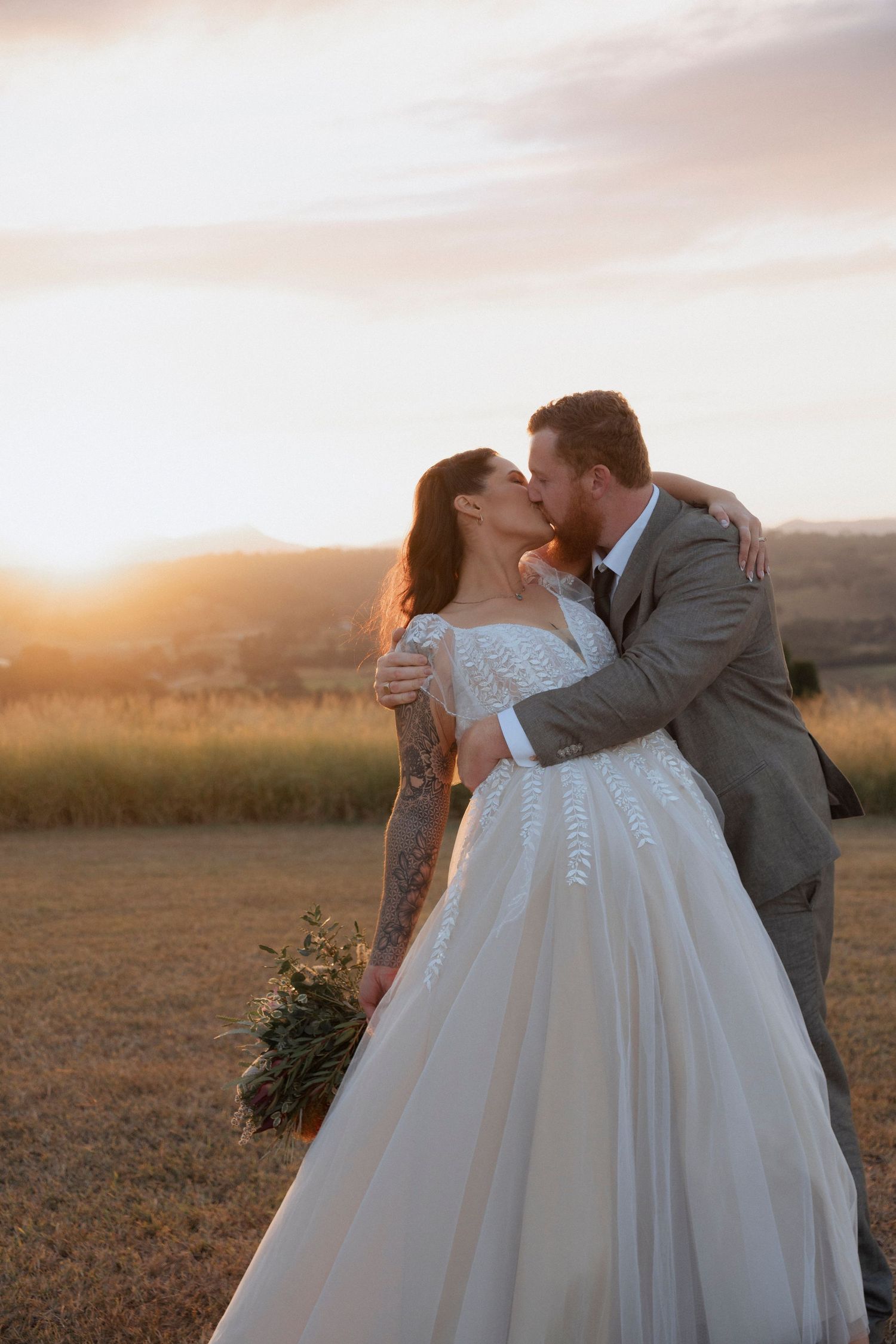 Couple embracing during golden hour with mountain views at Maroon Hill Estate near Boonah.