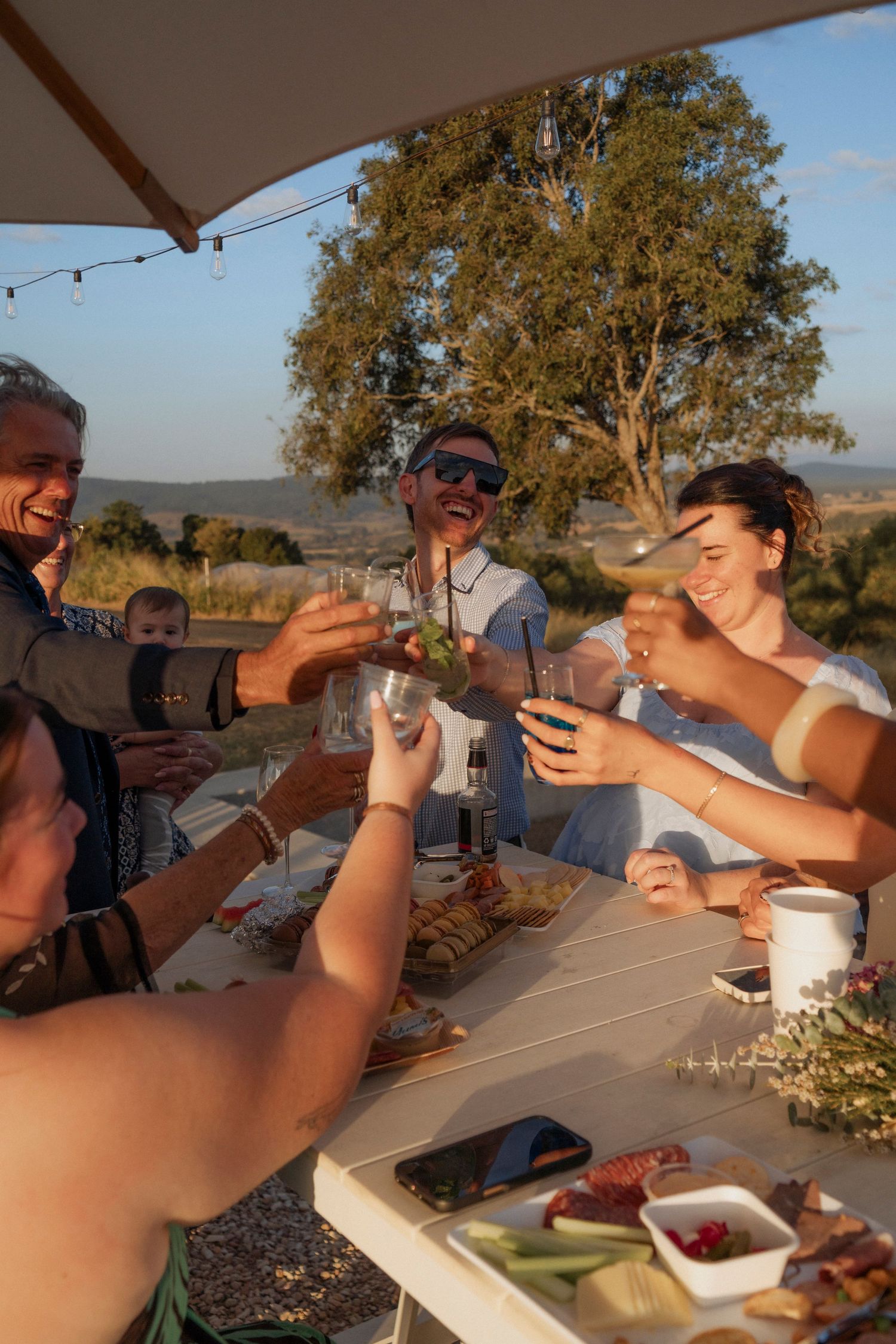 Guests cheers during sunset cocktail hour at maroon hill estate stunning dyi wedding venue in teh scenic rim documentary photography