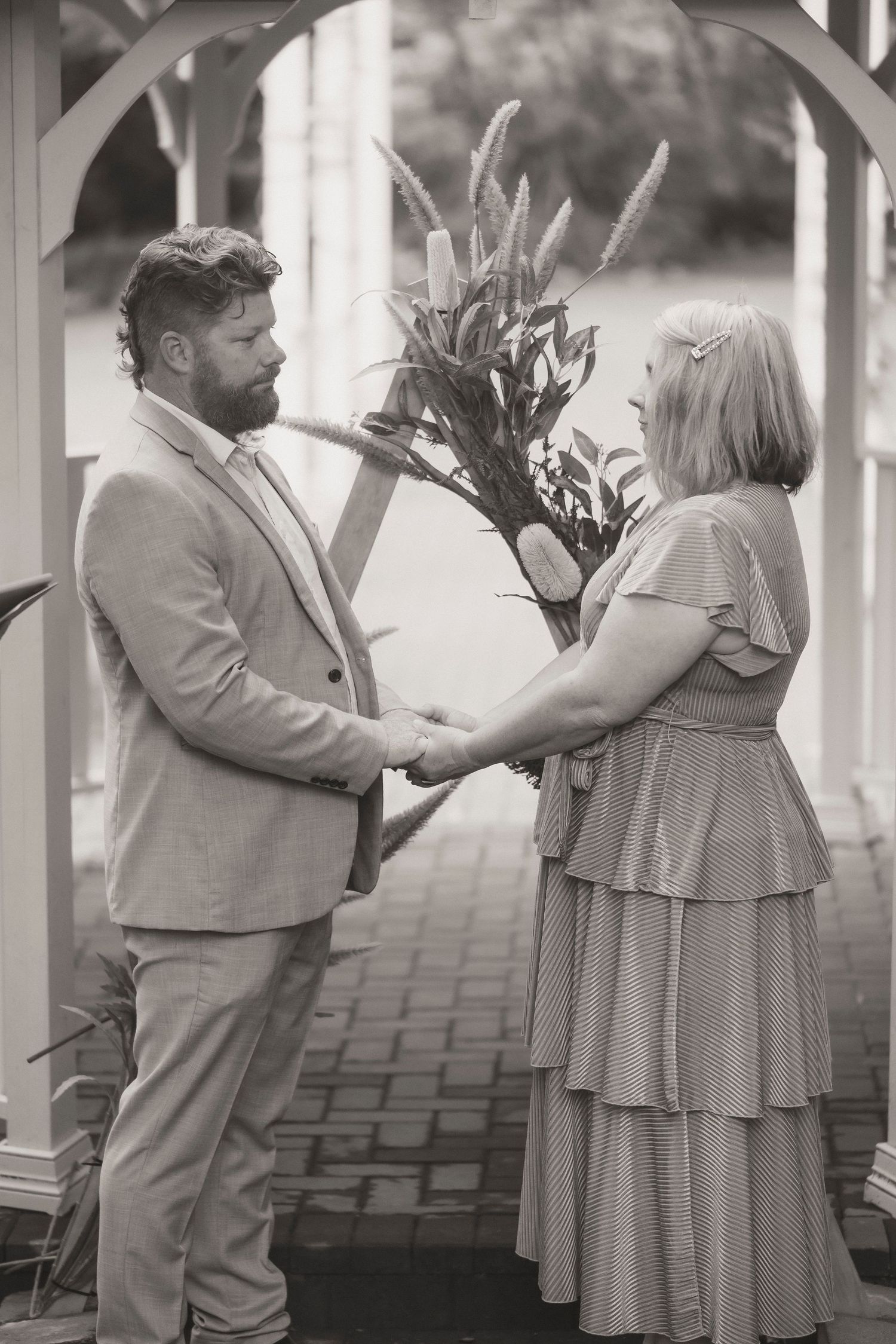 Couple exchanging vows during a 25 year anniversary vow renewal ceremony at Noosa Botanical Gardens, Sunshine Coast Queensland.