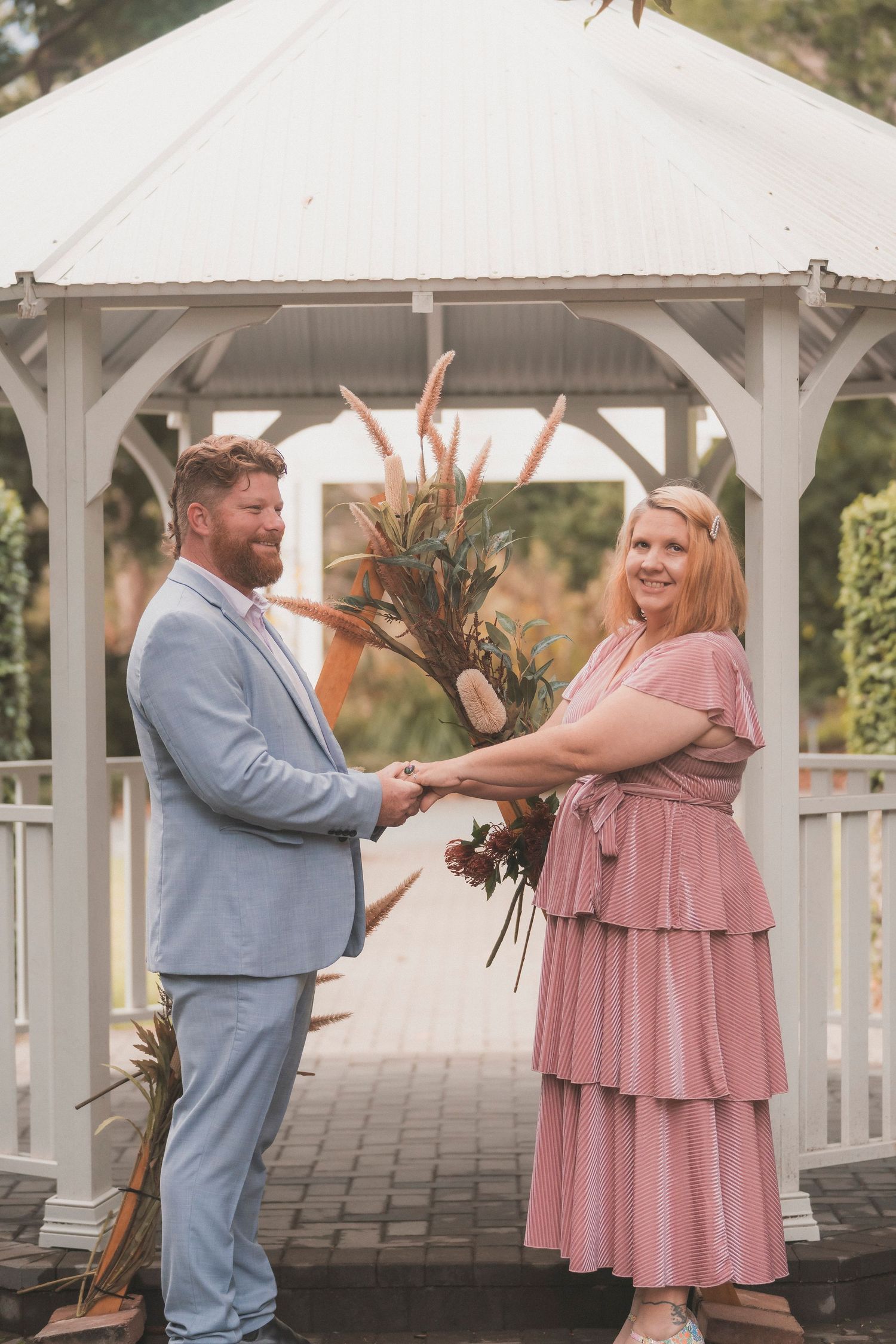 Couple exchanging vows during a 25 year anniversary vow renewal ceremony at Noosa Botanical Gardens, Sunshine Coast Queensland.