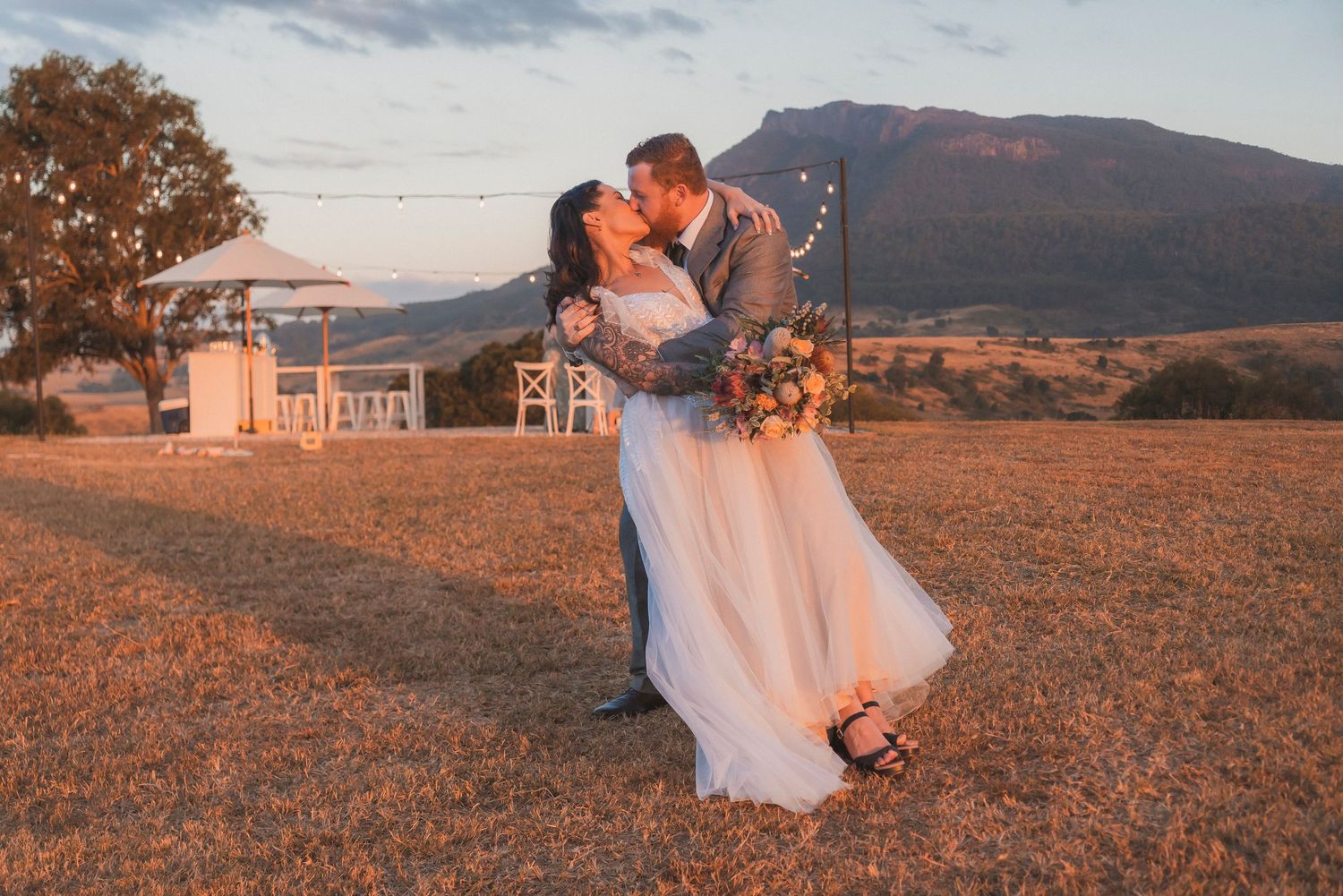 Bride and Groom dip kiss in front of mount maroon at maroon hill estate wedding venue photographed by shae imagery wedding photographer