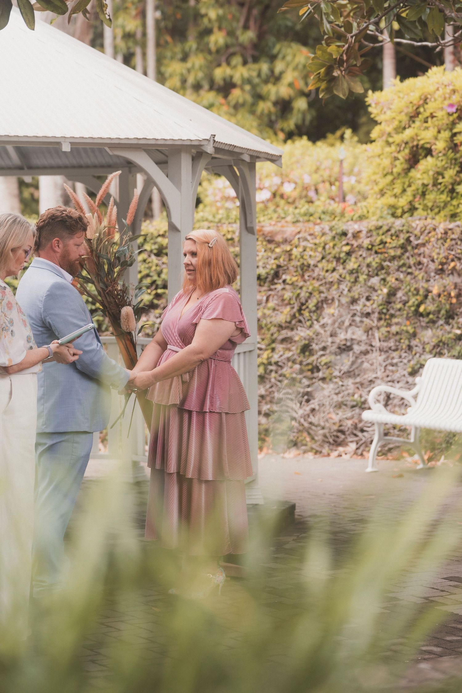 Bride and groom embracing during their surprise vow renewal at Noosa Botanical Gardens, captured by a Sunshine Coast documentary photographe