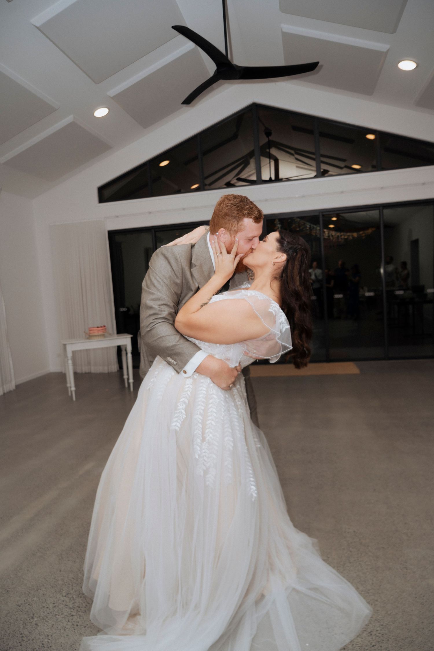 Bride and groom dancing beneath warm reception lighting at Maroon Hill Estate.