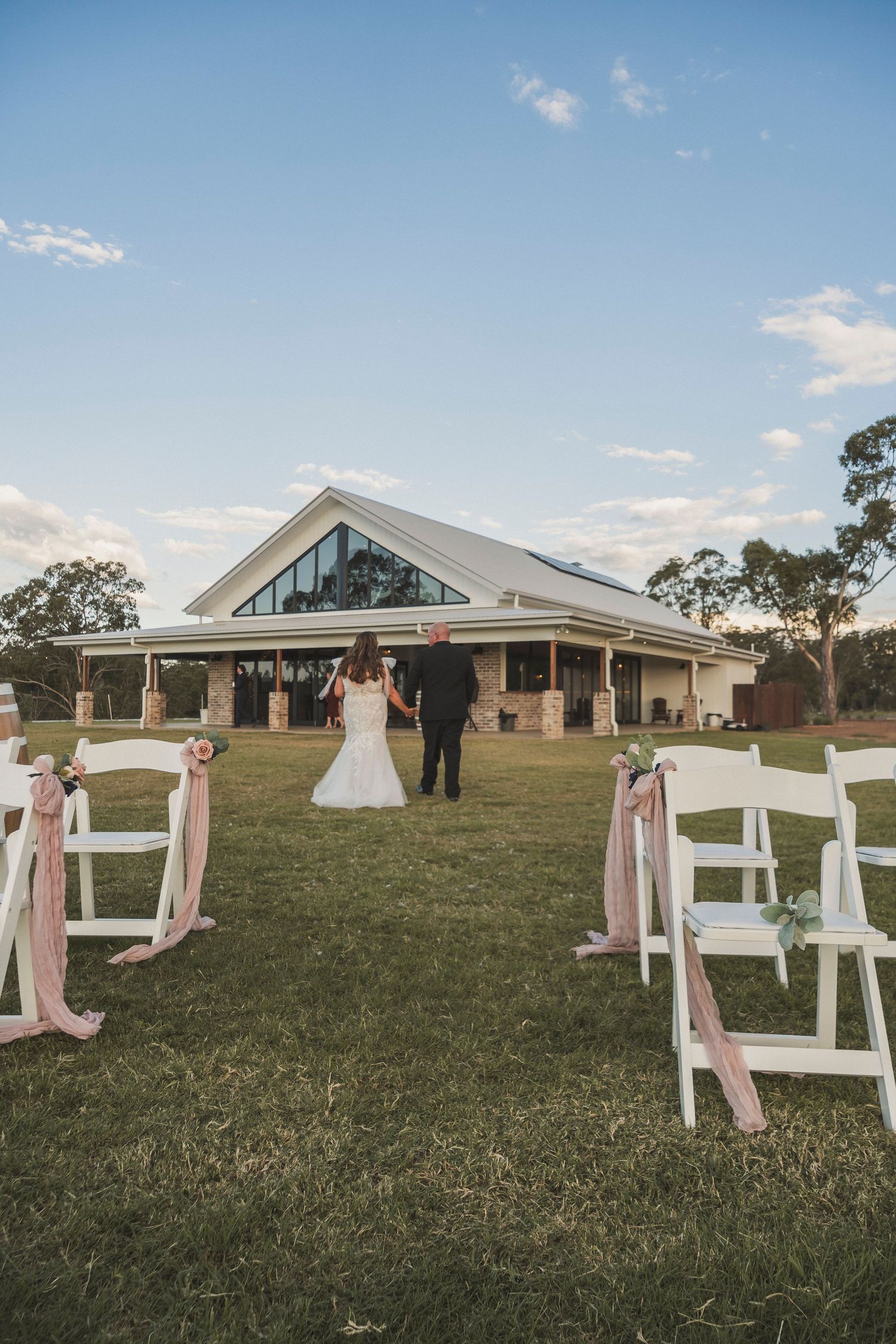 Bride and Groom walking back to wedding venue Keteka Hill Toowoomba Crows nest wedding venue Photos by Shae Imagery Wedding Photographer