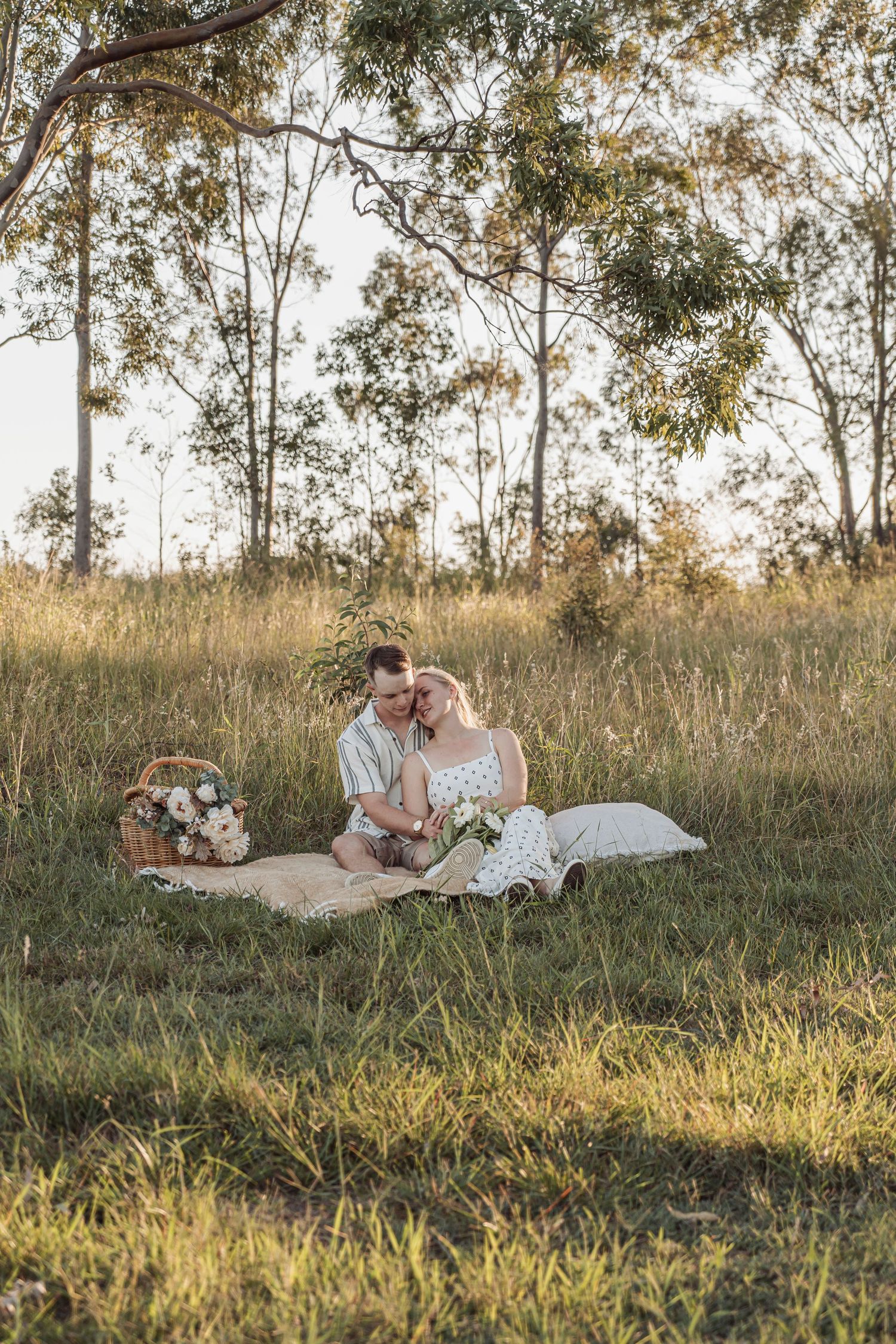 Engaged couple laughing during golden hour session in Lockyer Valley. Picnic staged editorial engagement. Photos are free with Wedding boo