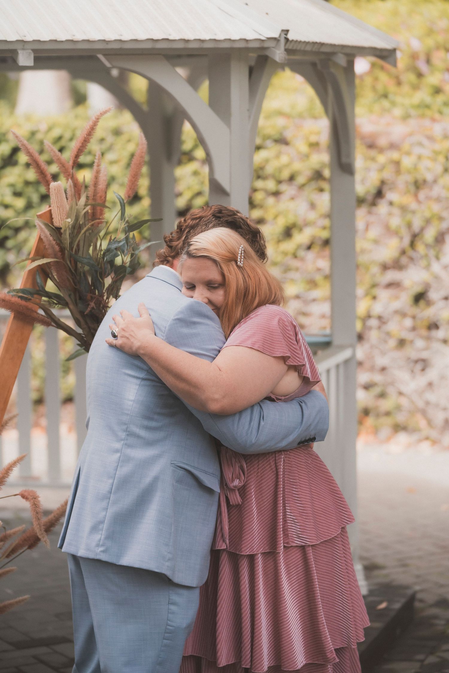 Bride and groom embracing during their surprise vow renewal at Noosa Botanical Gardens, captured by a Sunshine Coast documentary photographe