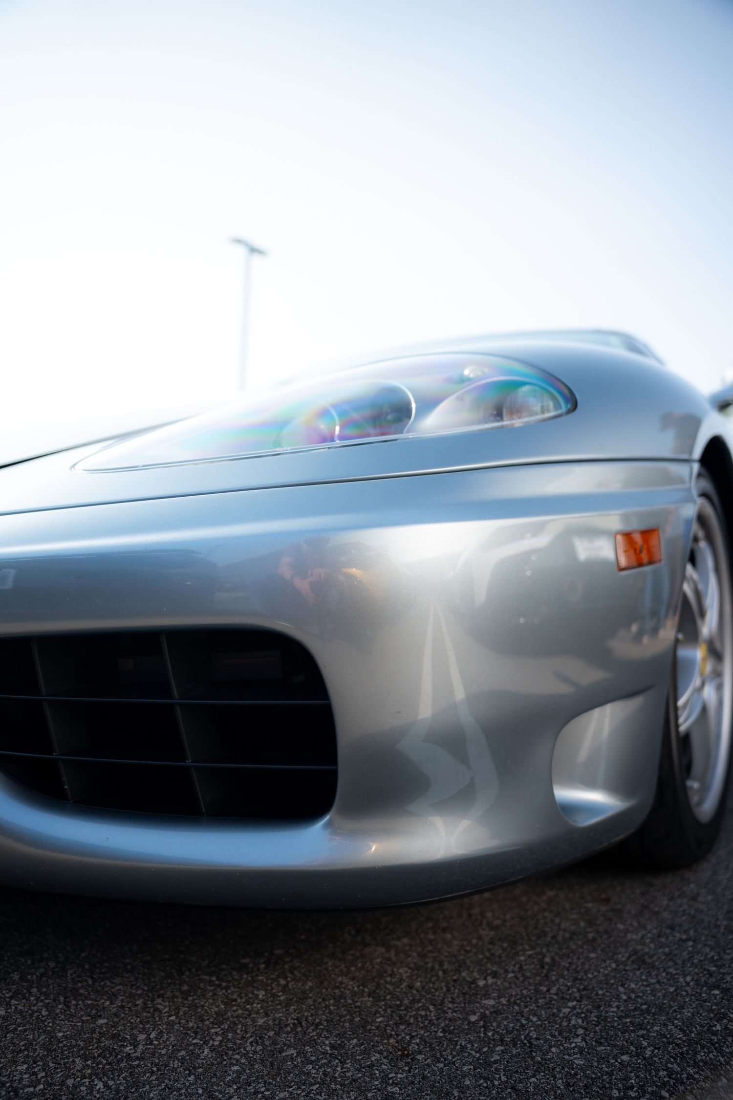Moody low-light image of a car lit by ambient or street lighting with strong reflections.