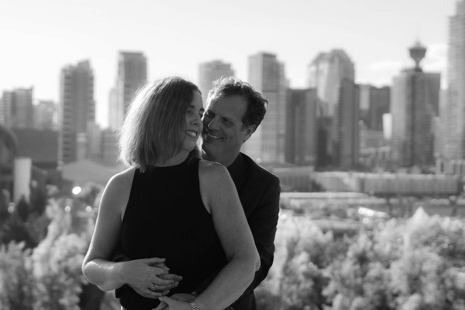 Couple smiling together with city views behind them