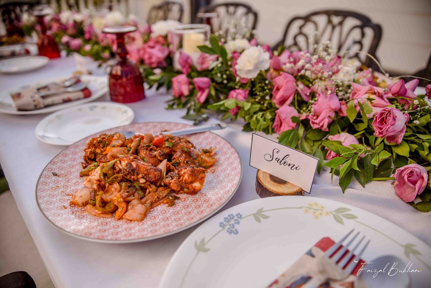 Bridal shower table with shrimp dish, pink floral runner, and personalized place card reading Saloni.
