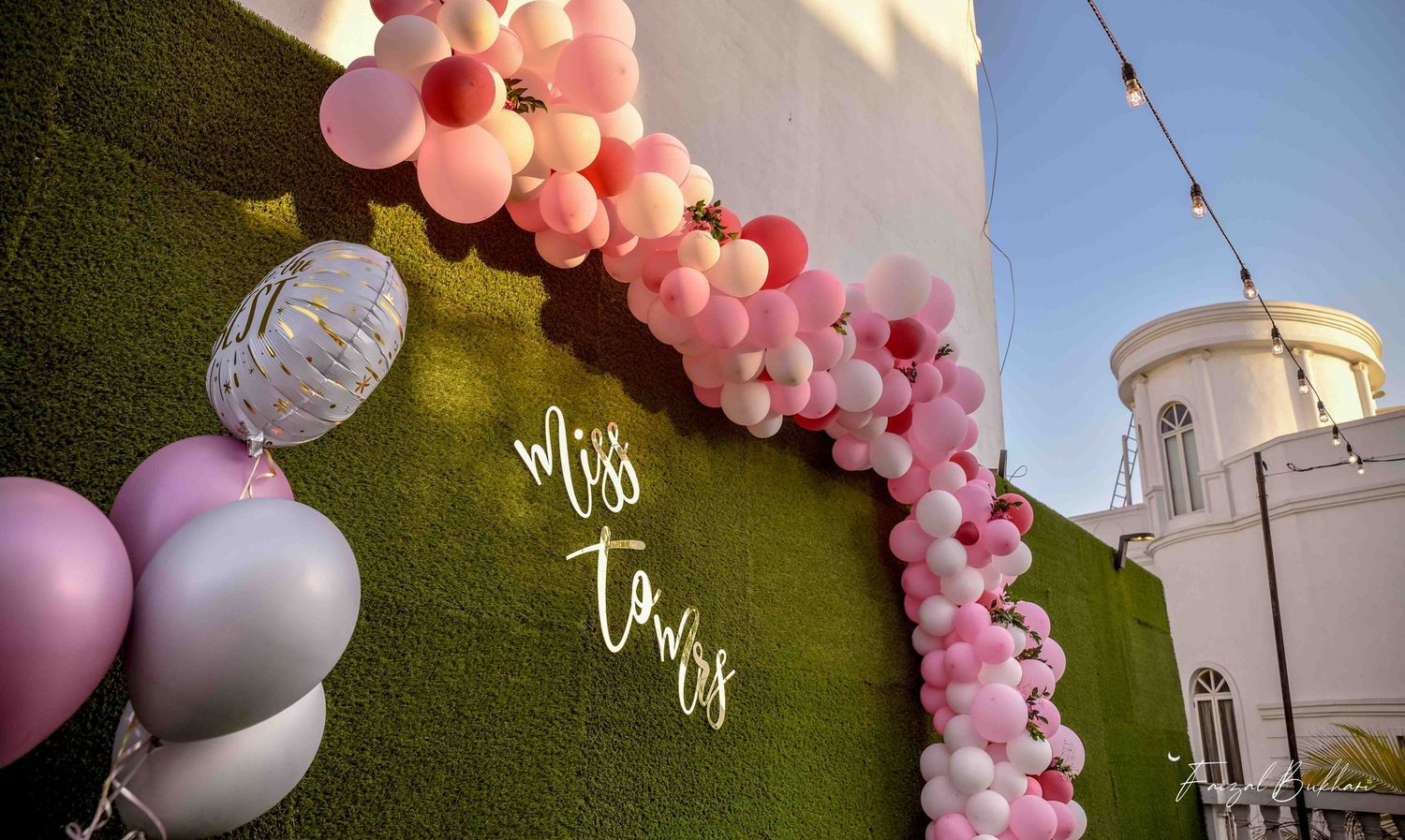Miss to Mrs bridal shower green wall backdrop with pink balloon garland.