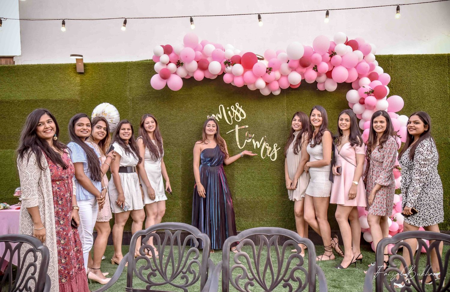 Bridal party group photo under pink balloon arch at a Miss to Mrs outdoor celebration.