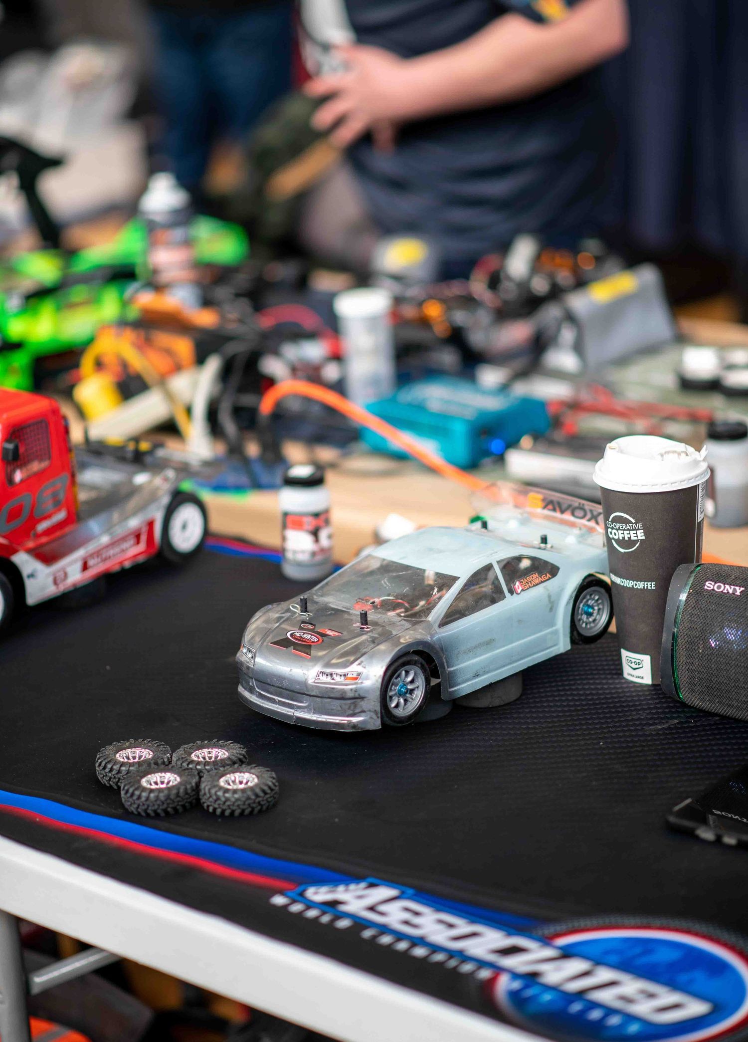 RC model cars and hobby equipment displayed on Associated Worlds mat.