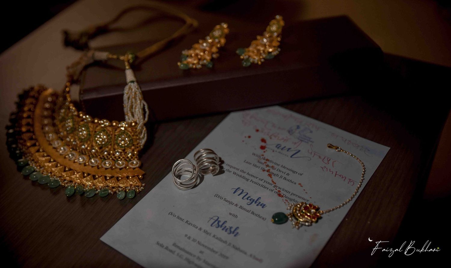 Traditional Indian bridal jewelry set with necklace and earrings displayed on wedding invitation card.