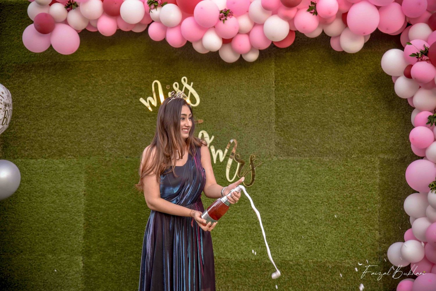 Bride celebrating at a pink and white balloon arch Miss to Mrs bridal shower party.