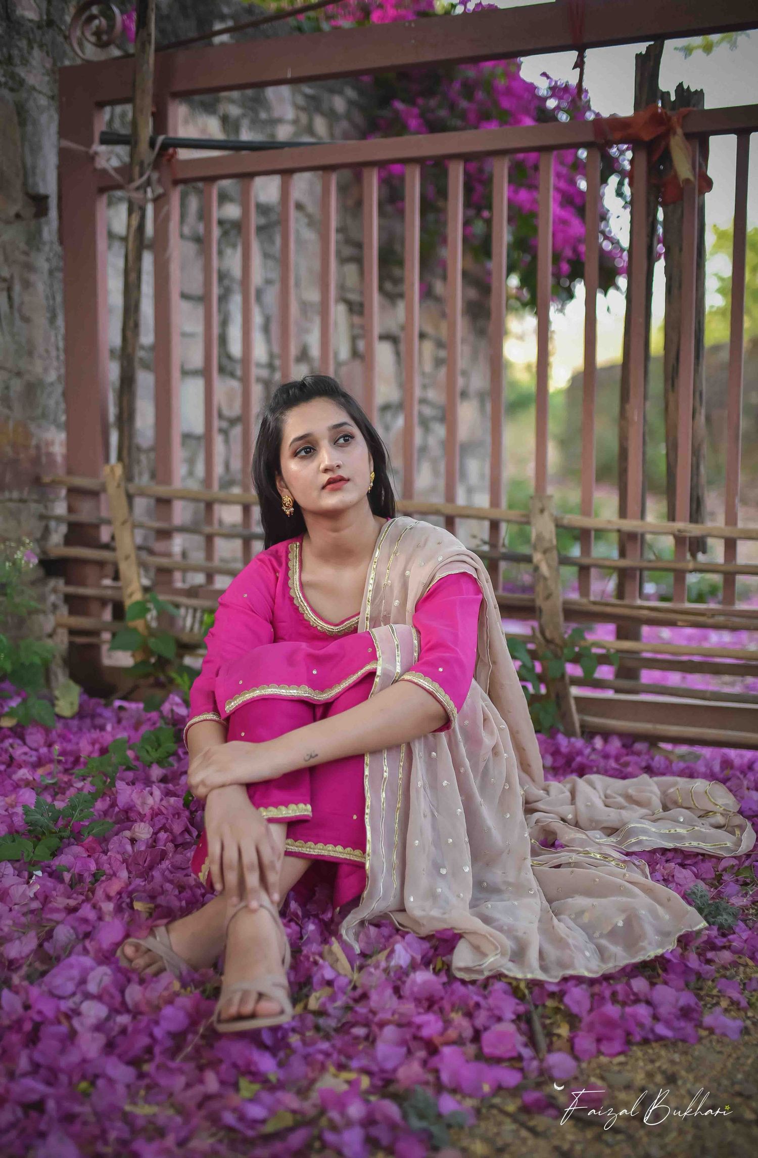 A girl in an Indian outfit blends into a sea of matching petals. Dreamy South Asian fashion photography in Kamloops, BC.