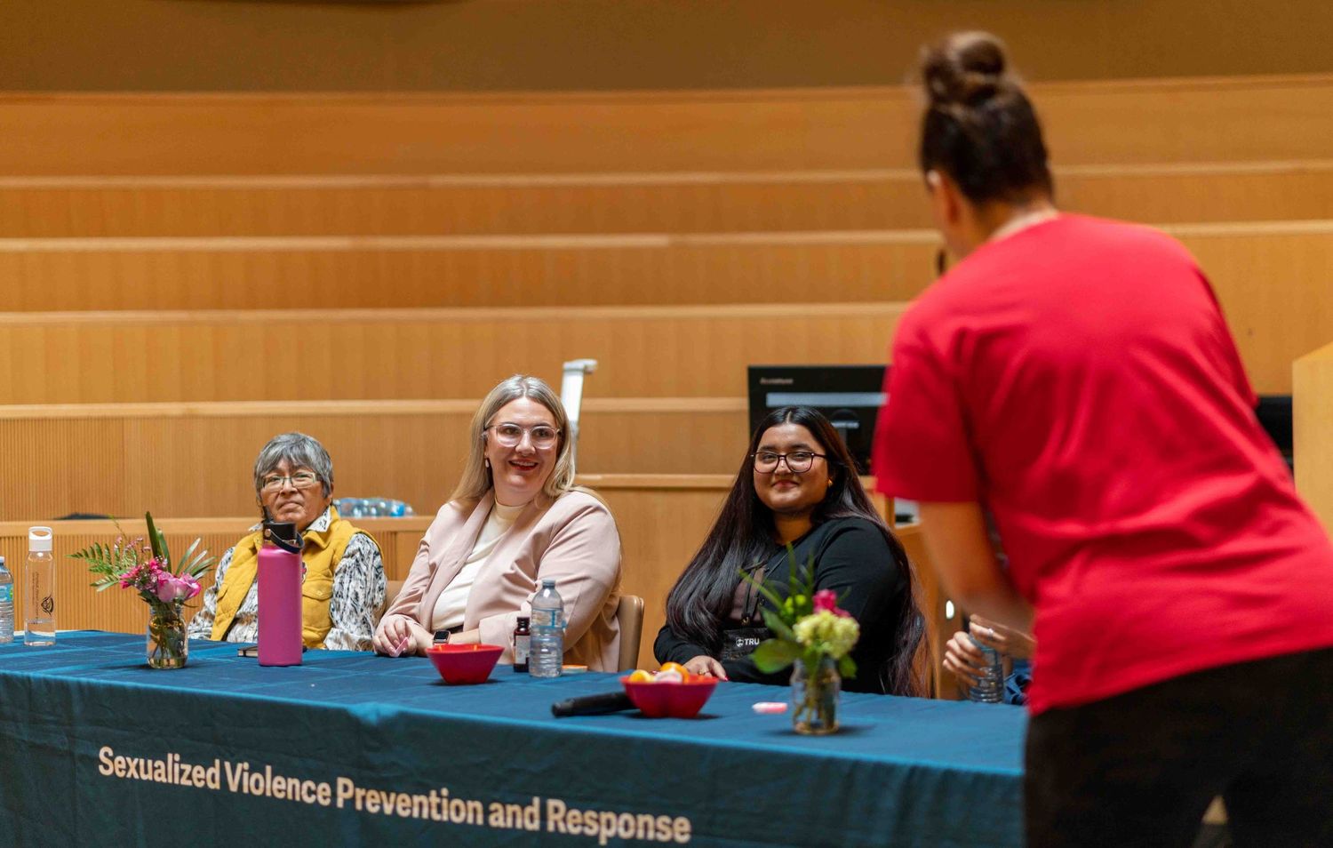 Three panelists smiling at Sexualized Violence Prevention Response table.