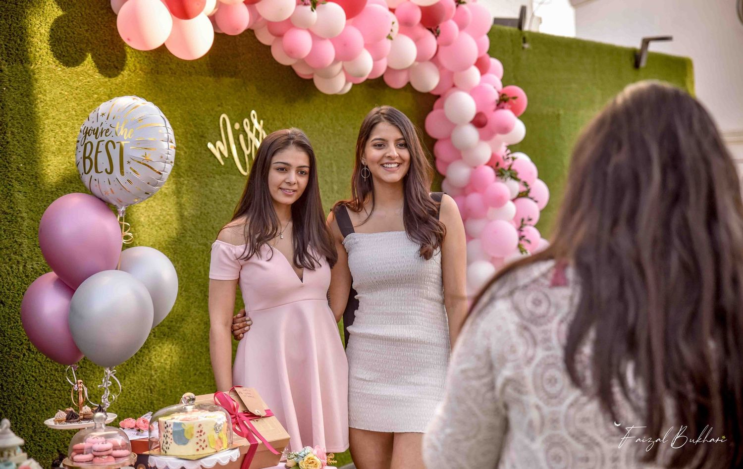 Two women posing at a Miss to Mrs bridal shower with pink balloons.