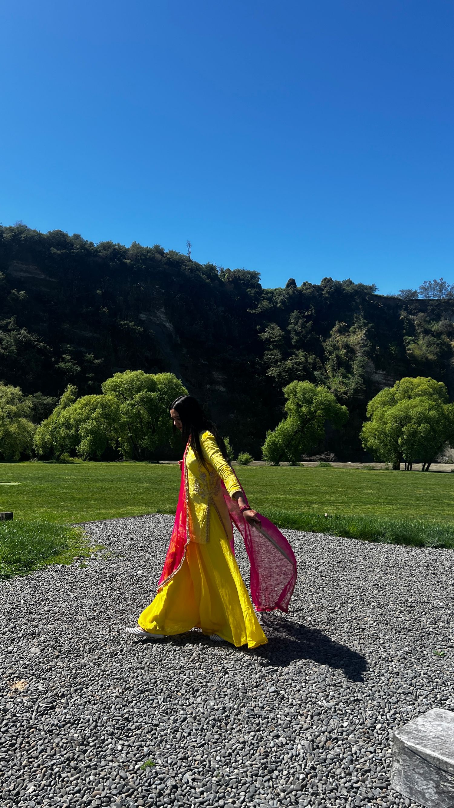 Colorful traditional dress flowing in the wind against a scenic mountain backdrop.