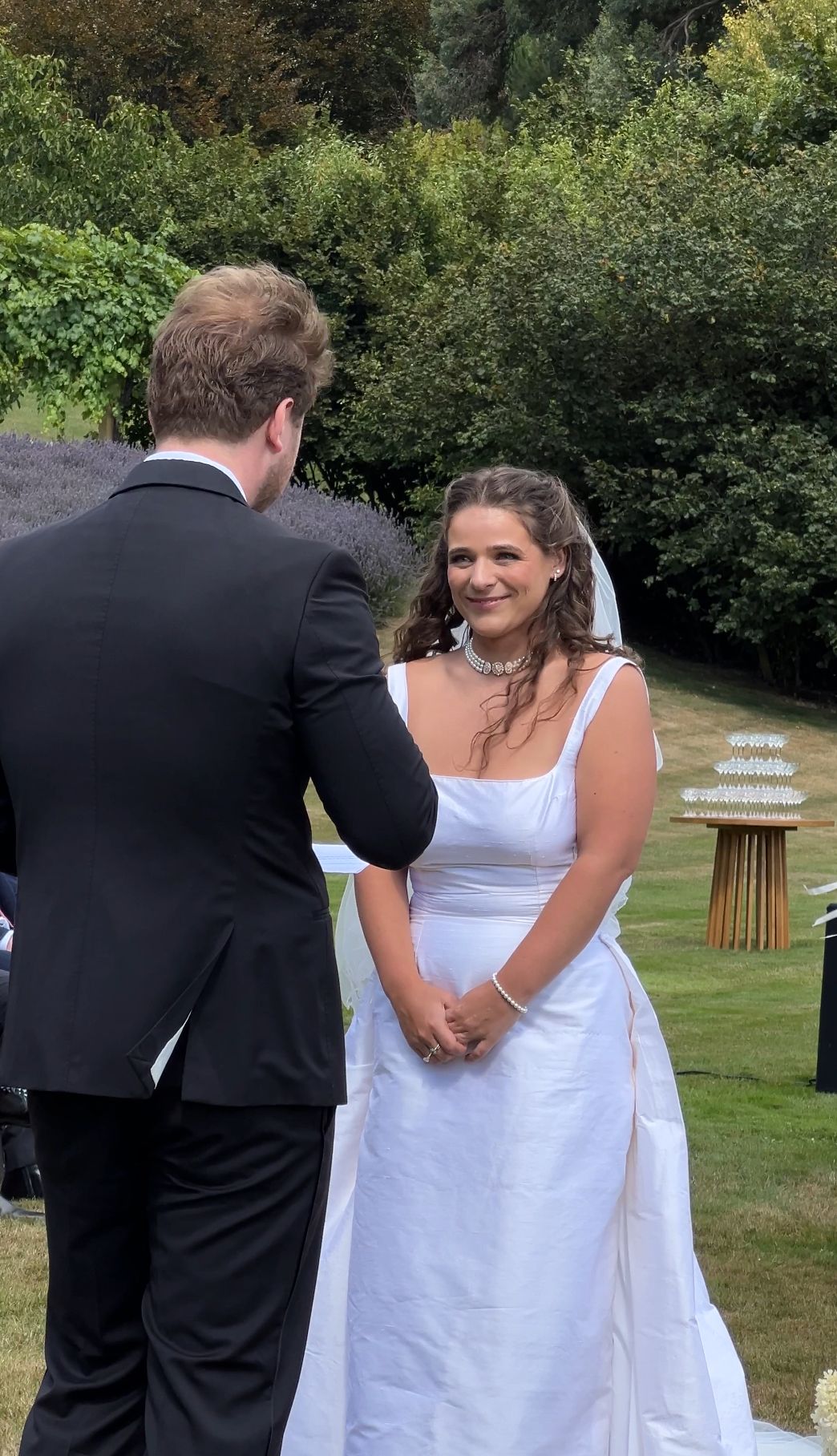 A series of wedding photos showing a couple in formal attire sharing a special moment in a garden setting.