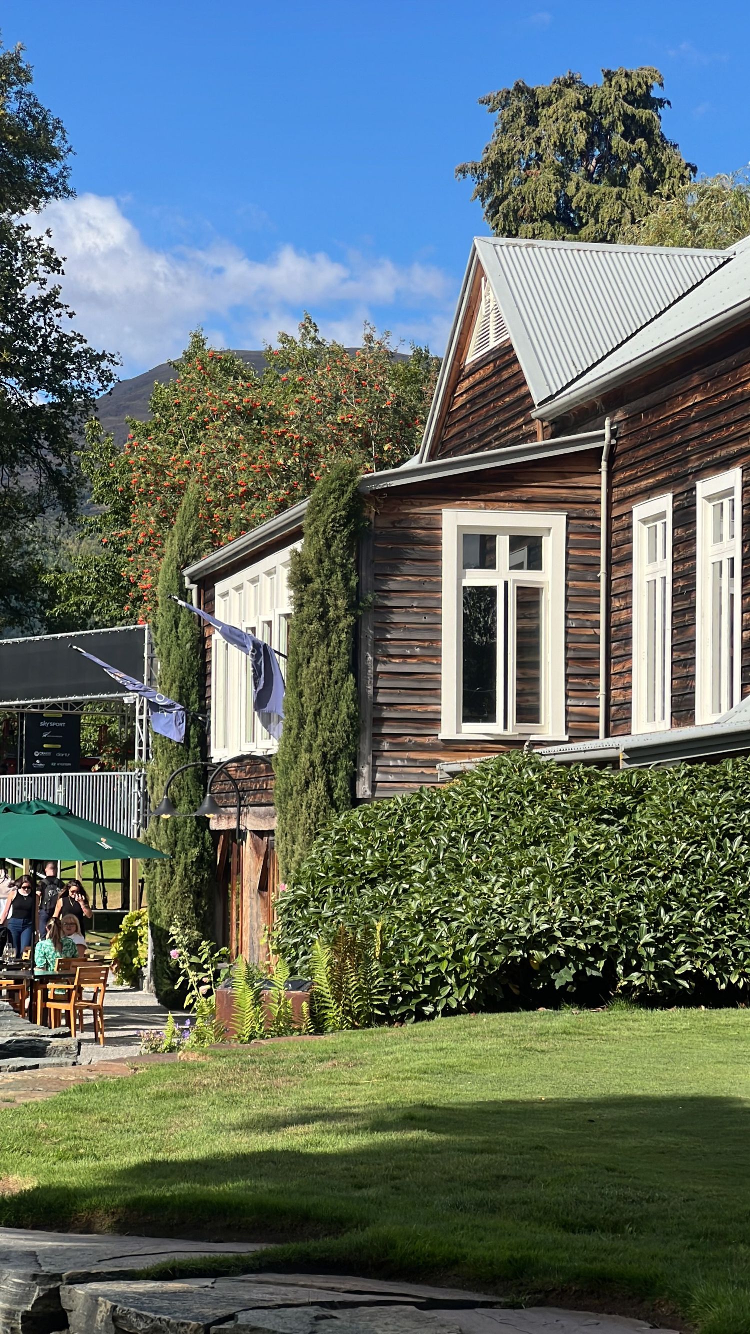 Wooden cottage buildings with white trim set against a green lawn and landscaping.