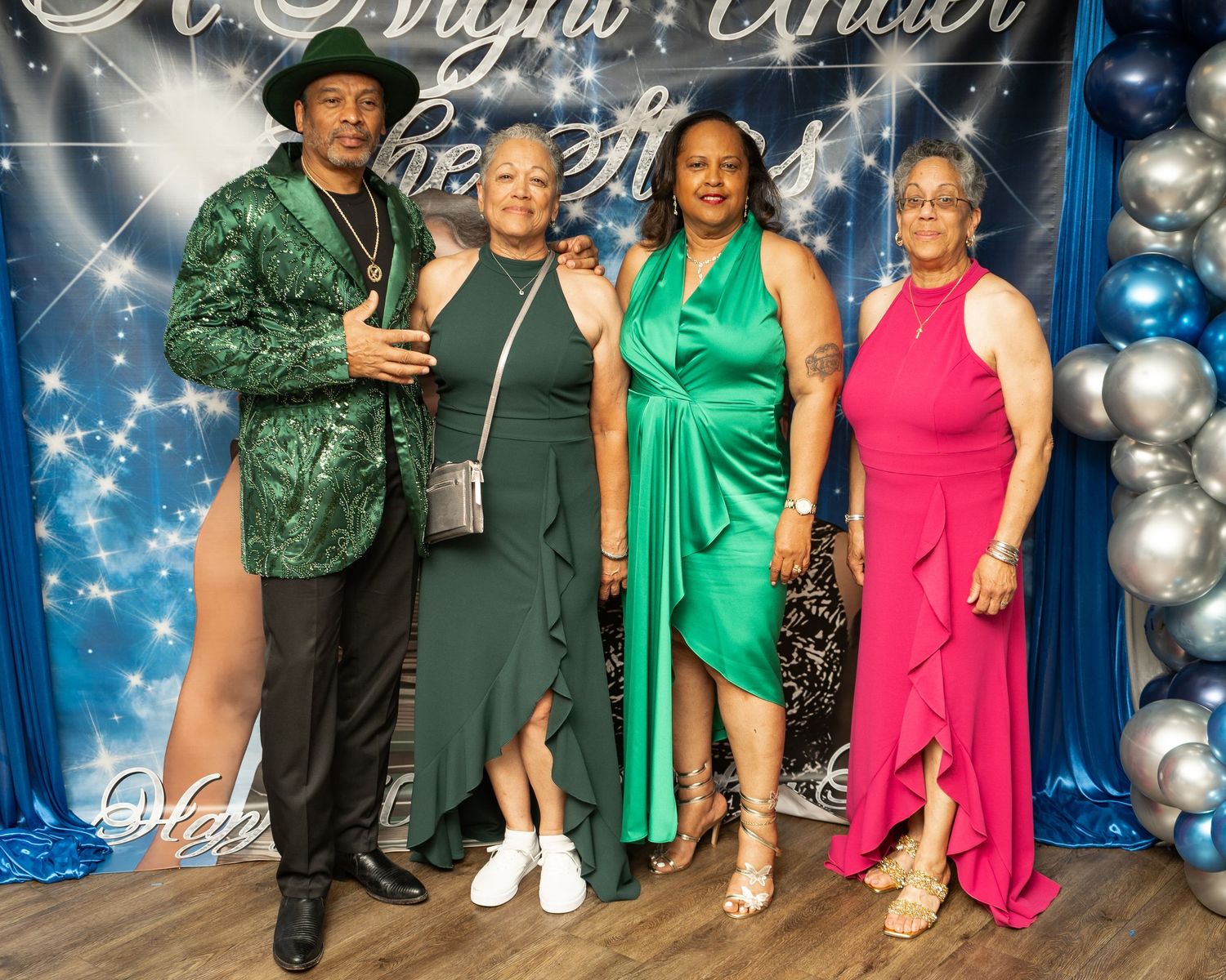 Elegant event portrait in Mableton, Georgia — four guests posing in vibrant formal attire at a “Night Under the Stars” celebration.