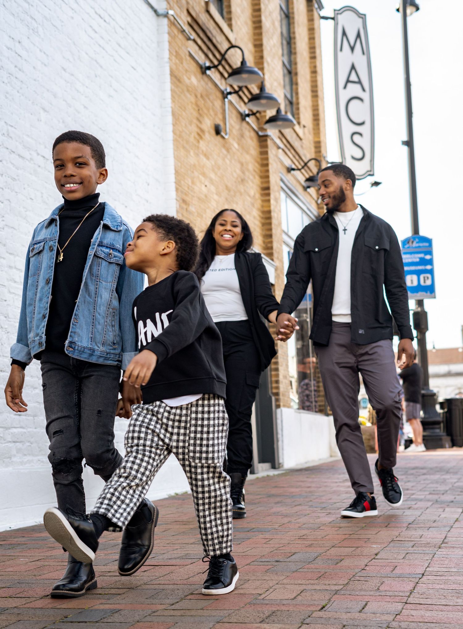 Lifestyle family photo session in Marietta, Georgia — family walking together downtown with candid smiles and city-brick charm.
