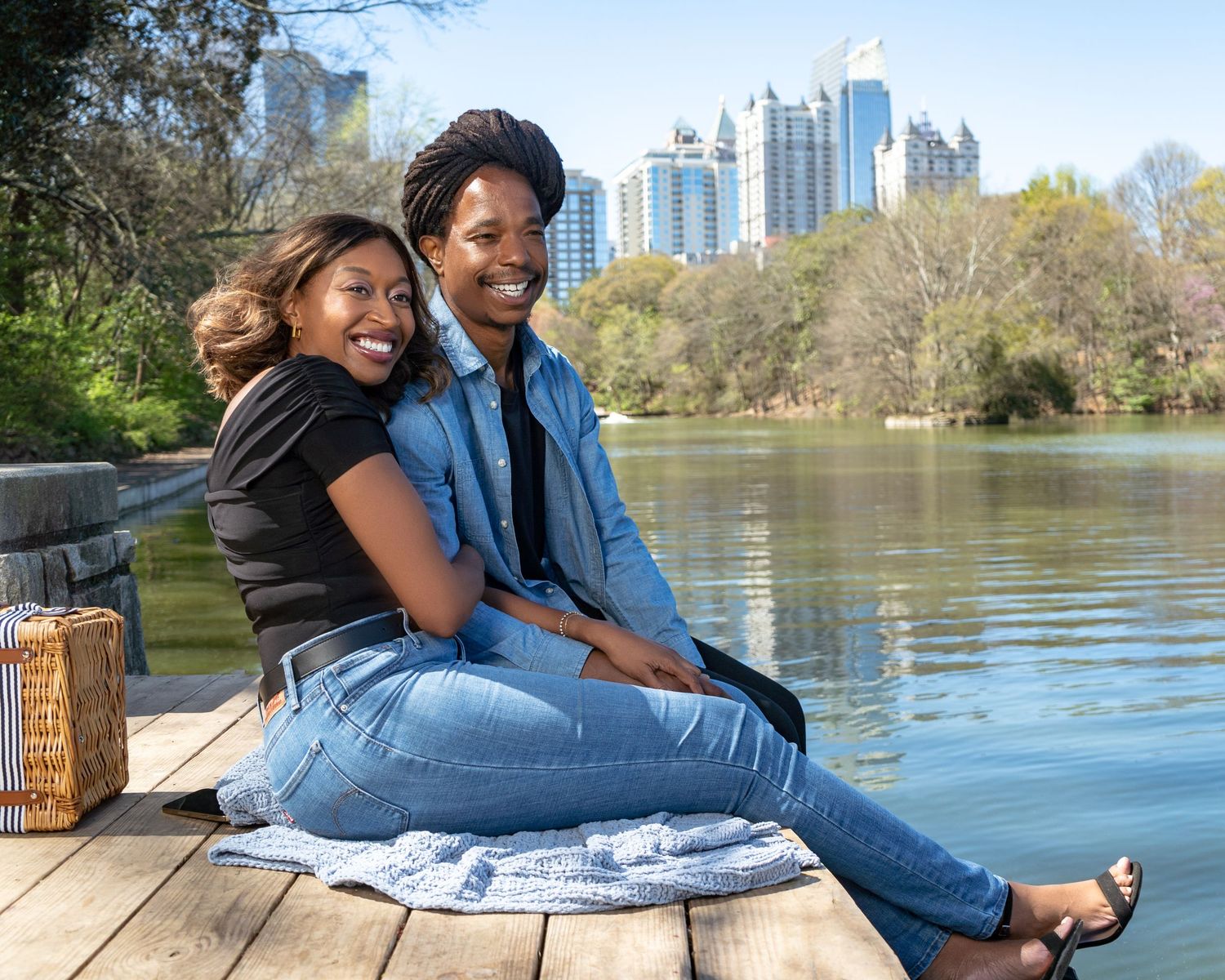Engagement photo of young black couple embracing beside the water at Piedmont Park in Atlanta.