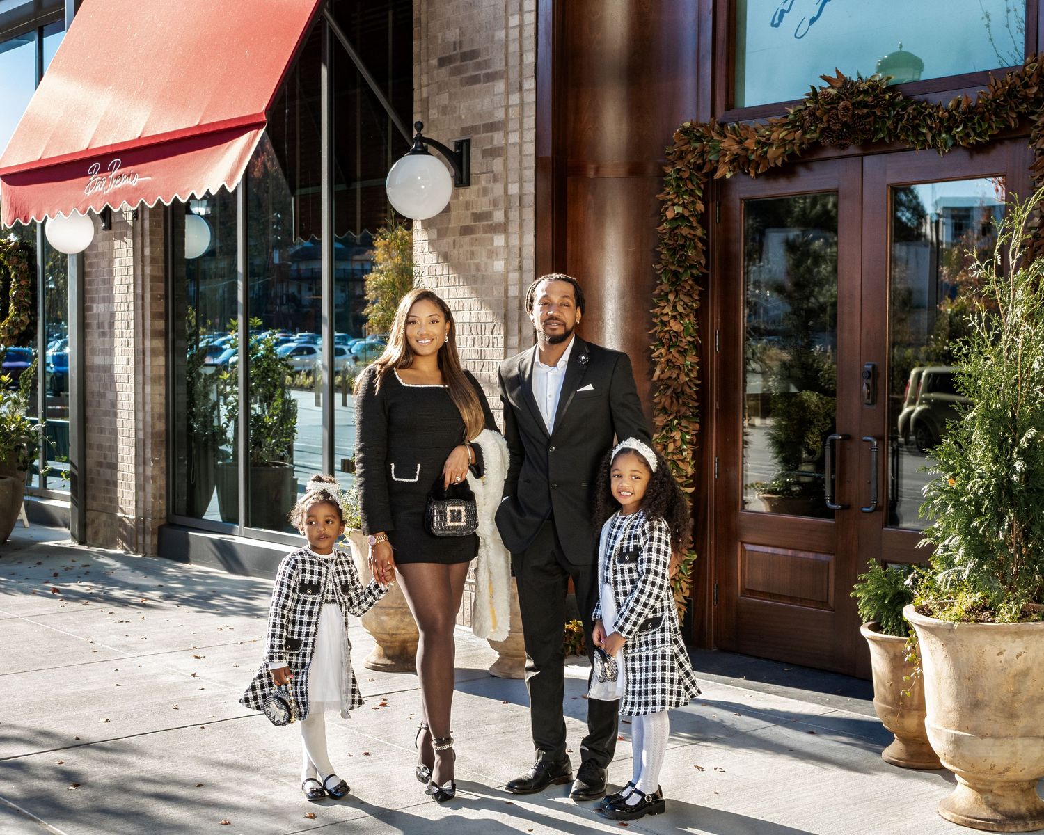 Stylish black family portrait in Vinings, Georgia parents and twin daughters dressed in coordinated black-and-white outfits