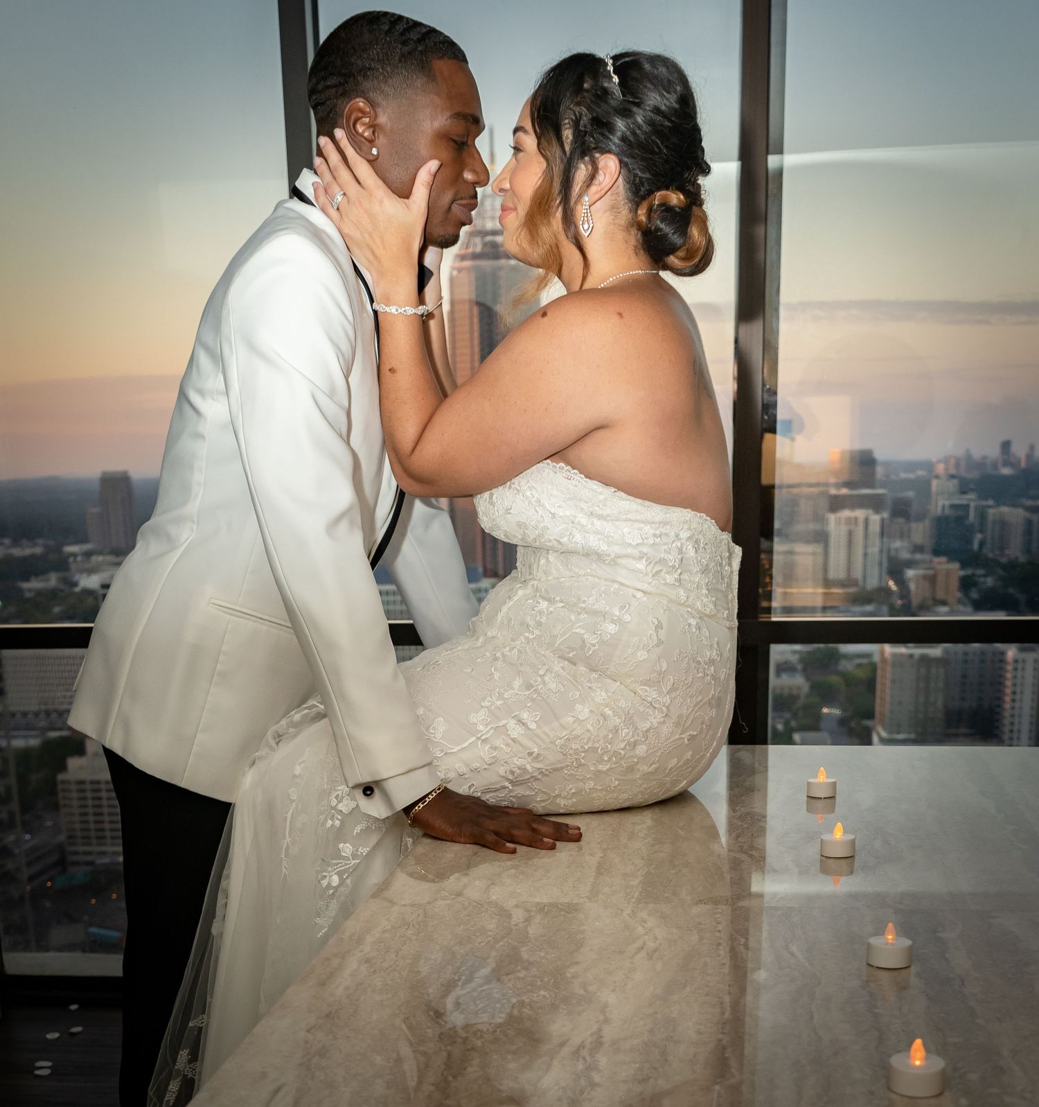 Romantic wedding portrait in Atlanta, Georgia — newlyweds sharing an intimate moment at sunset with a city skyline backdrop.