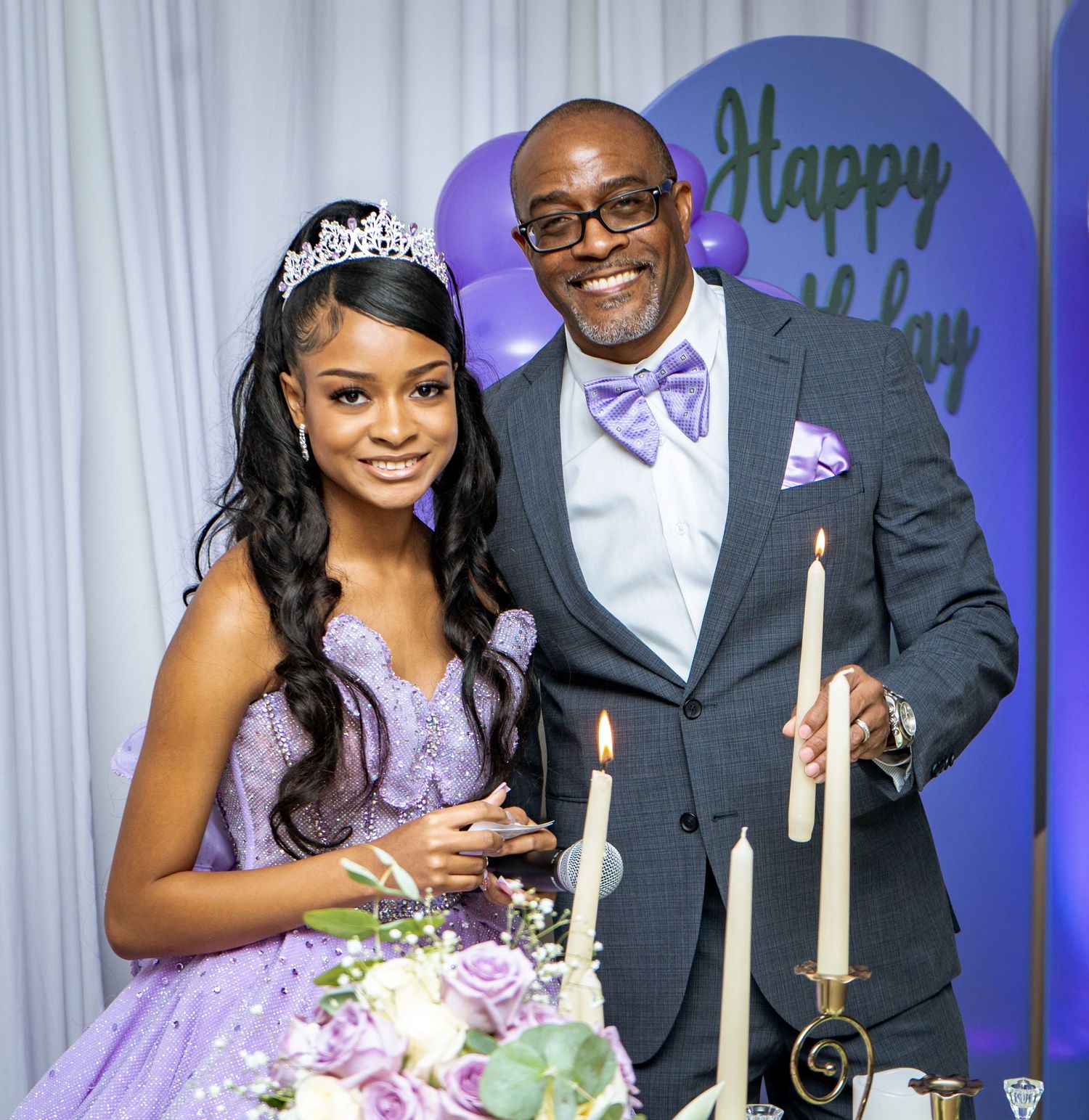 Elegant birthday celebration featuring a young woman in a lavender gown and tiara standing beside her father in a gray suit — captured in a