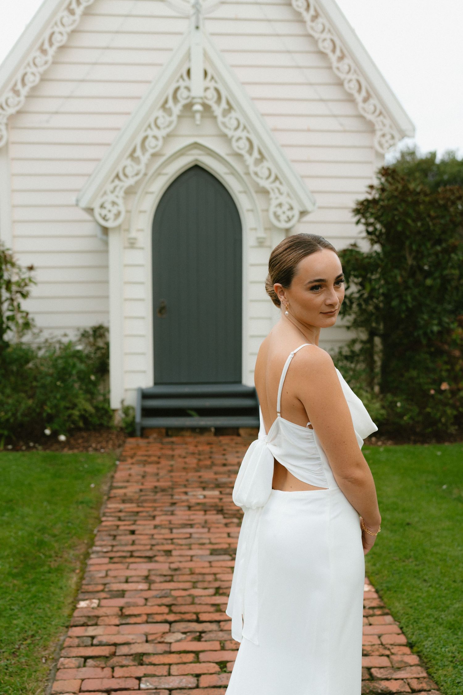Classic white chapel wedding venue with ornate trim and brick pathway.