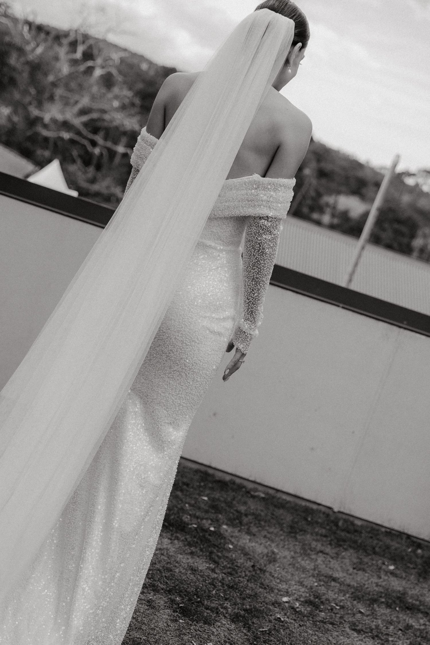 Close-up details of a white wedding dress with delicate lace and beading.