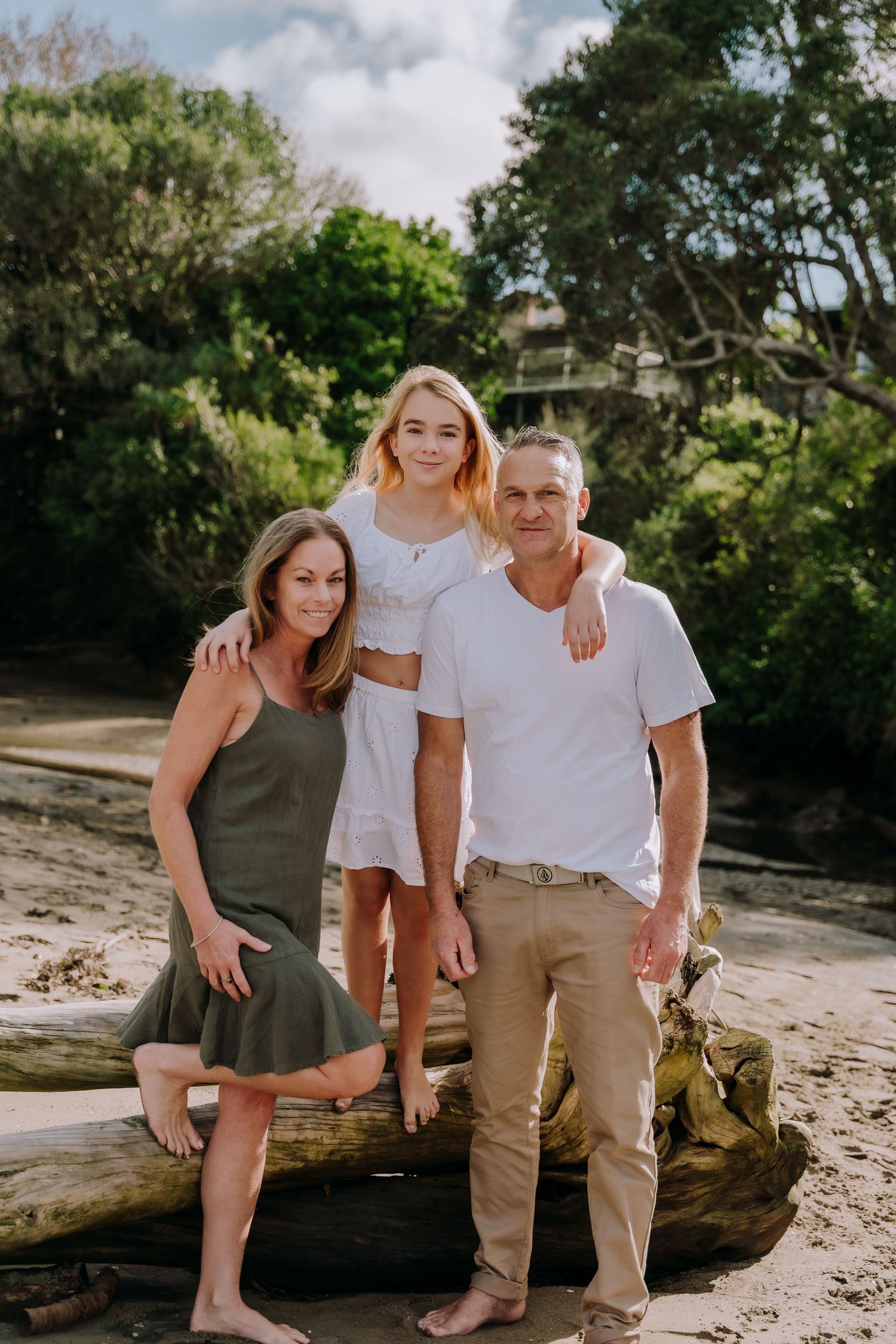 Casual family photo shoot on a scenic beach with natural lighting.