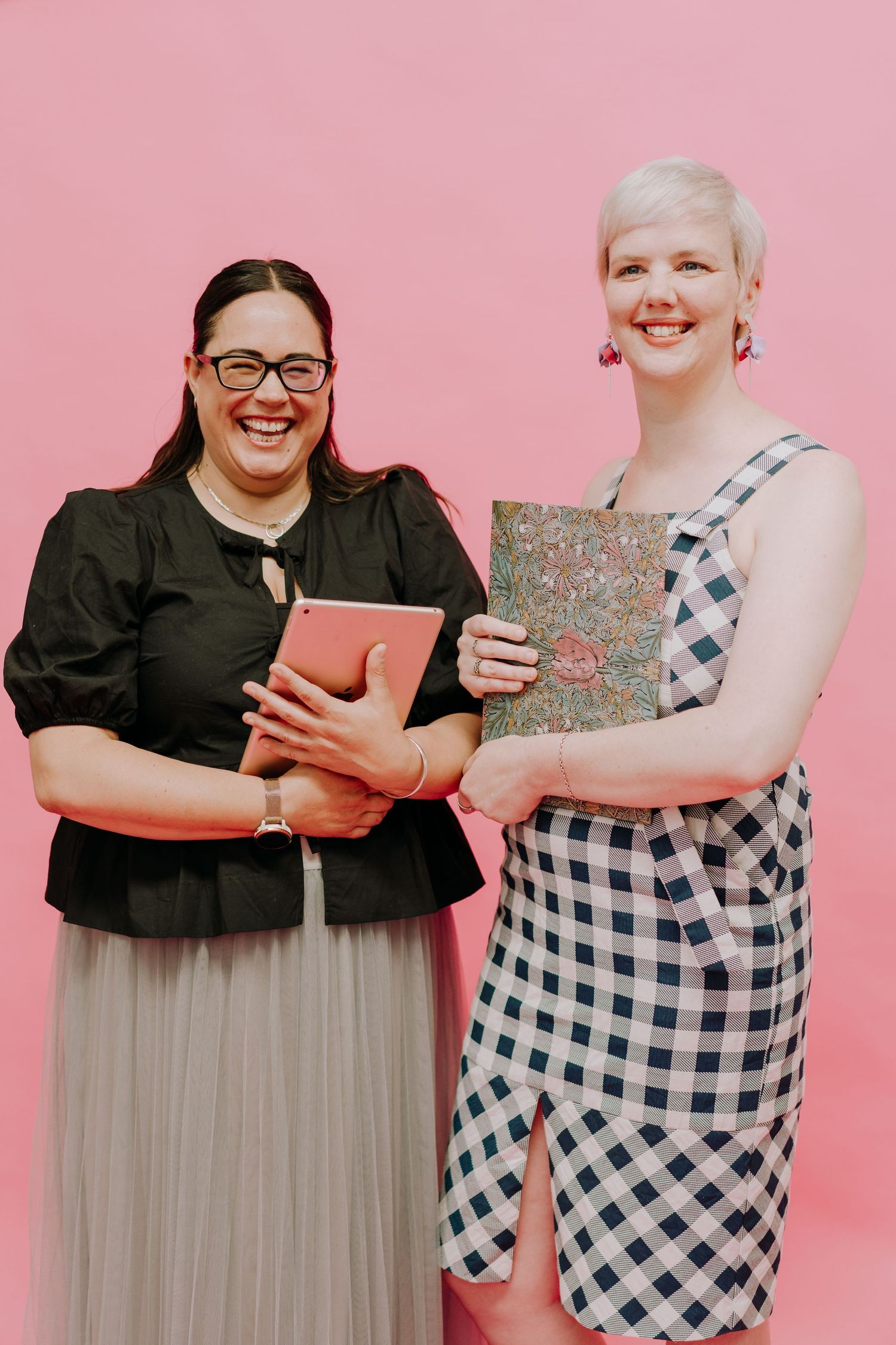 Two people in black and gingham outfits pose playfully against a pink background in a photo sequence.