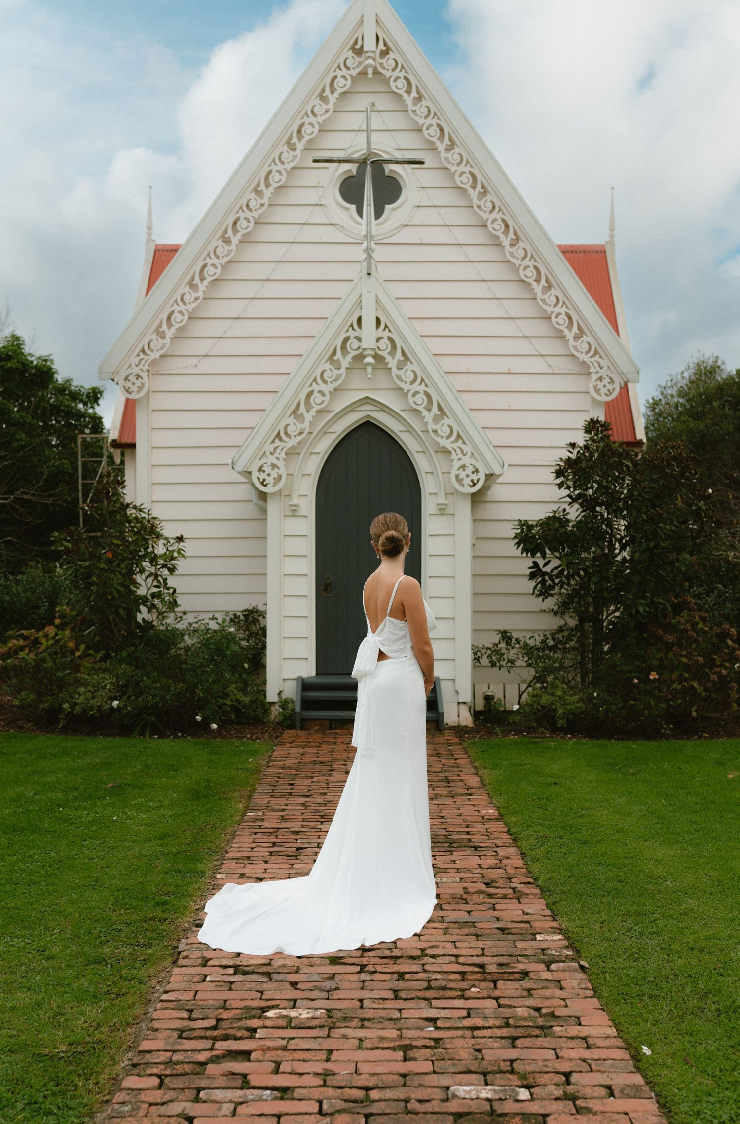 White wedding dress silhouette against charming historic chapel architecture.