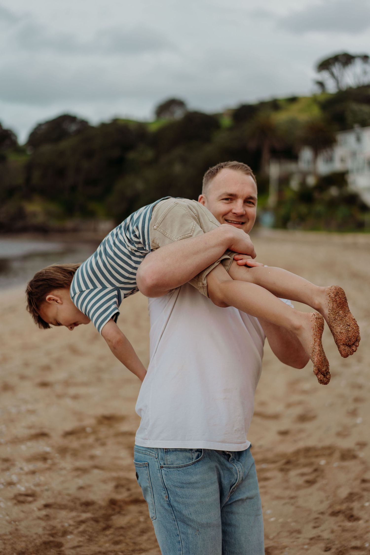 A playful sequence of images showing a couple embracing and spinning on a sandy beach at sunset.