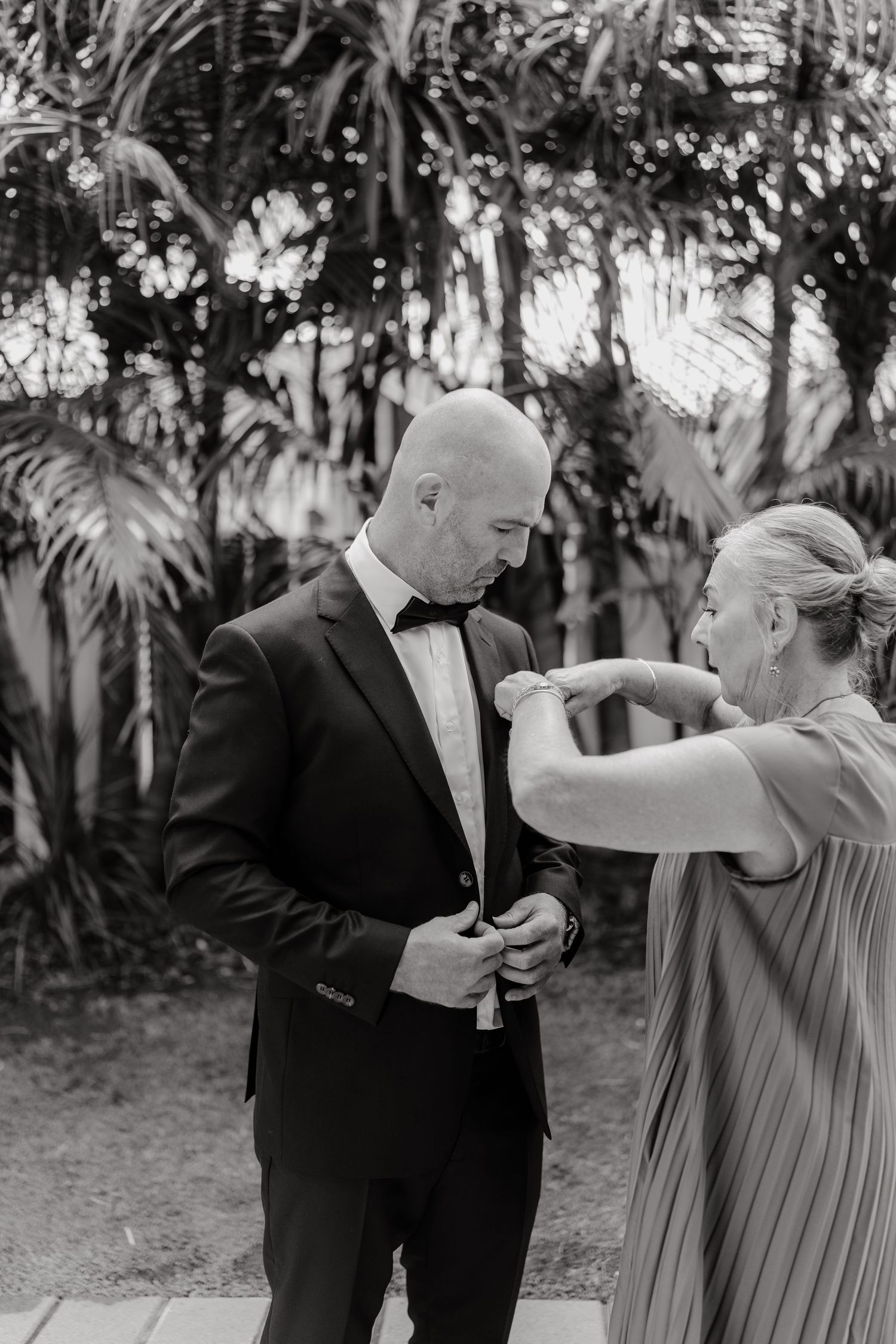 Wedding party members share emotional moments in black and white photography sequence.