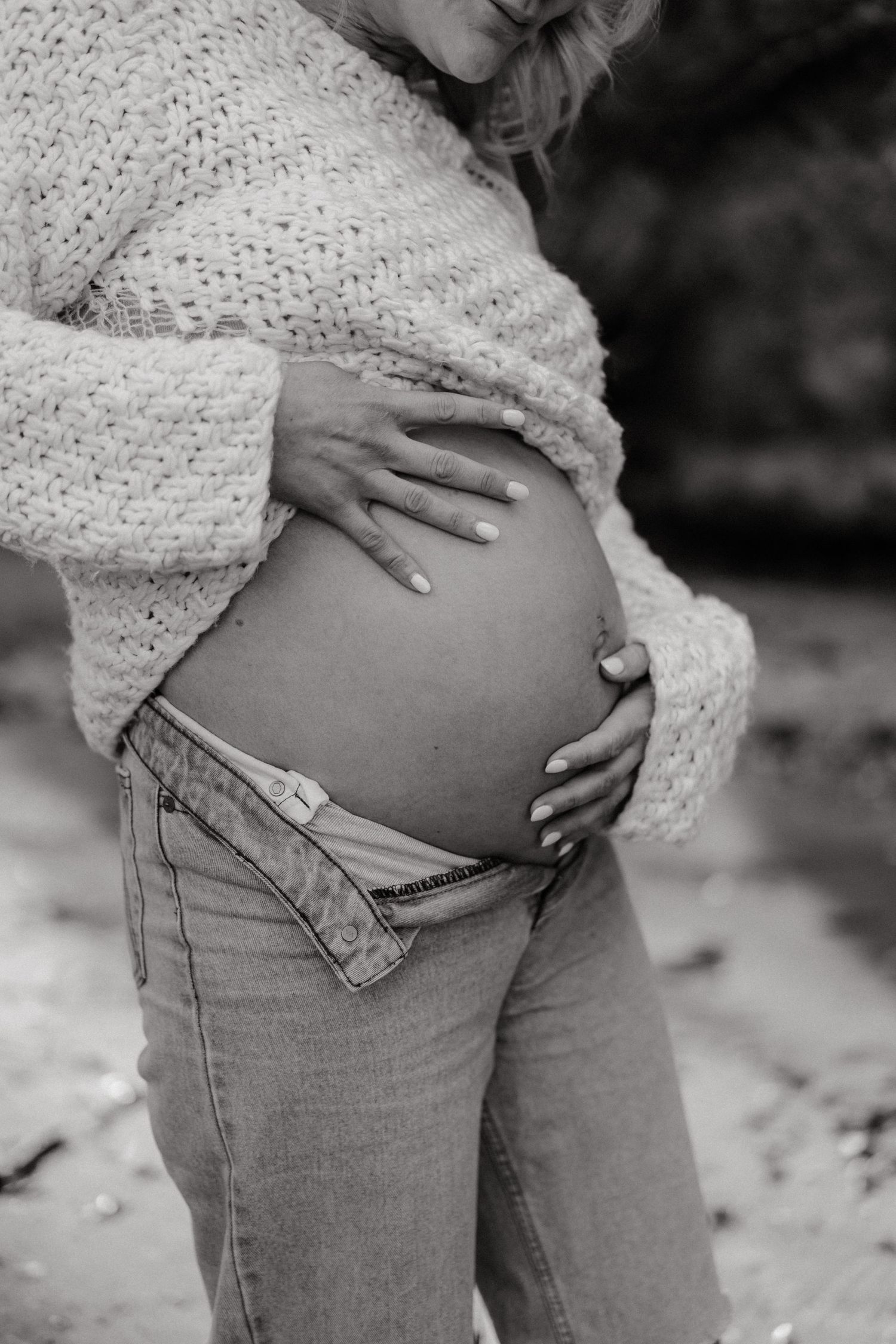 Close-up maternity shots showing pregnant belly with hands resting gently on bump.