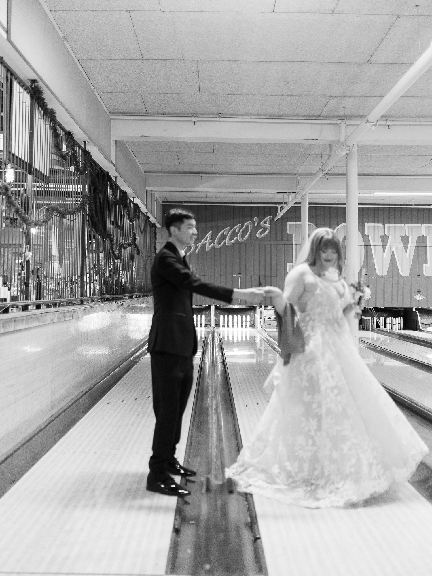 A couple in formal attire having fun bowling together at a bowling alley at Flatbreads in Somerville..