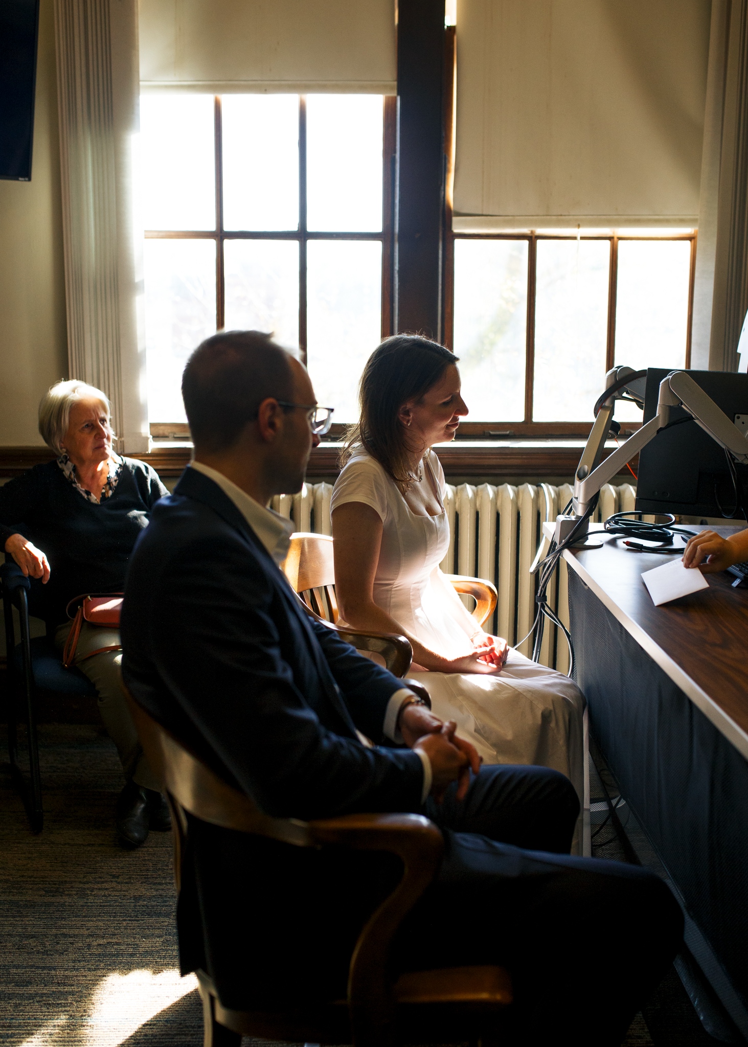 People sit in a meeting room with natural light streaming through windows during a business gathering.