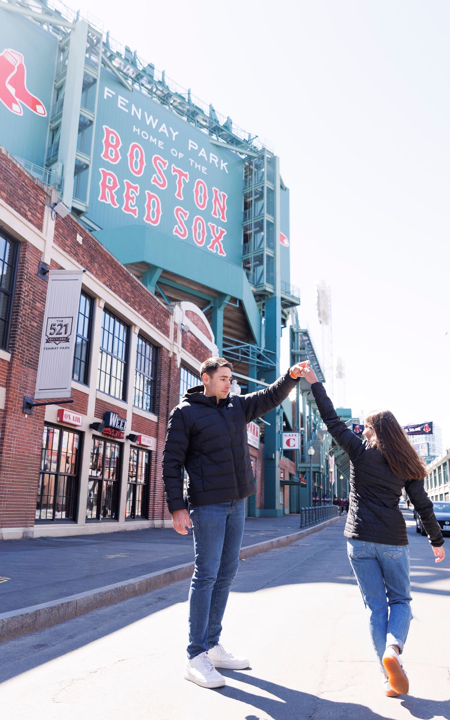 Couple dancing outside Fenway Park, home of the Boston Red Sox, on a sunny day.