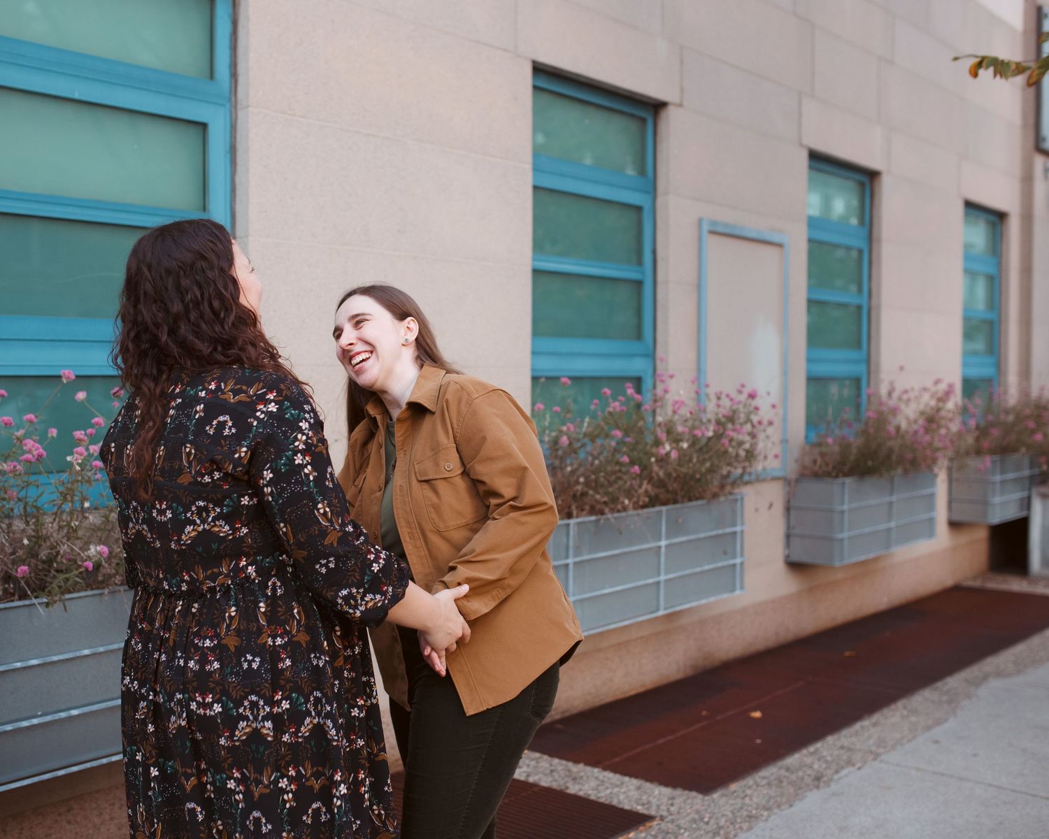 A person in a brown sweater leans against a blue wall while laughing and expressing joy in a series of candid moments.