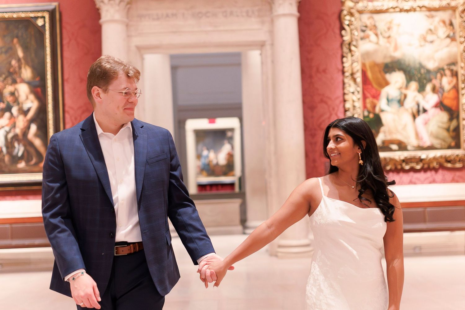 Couple dancing together in an elegant museum gallery with ornate artwork and paintings on display.