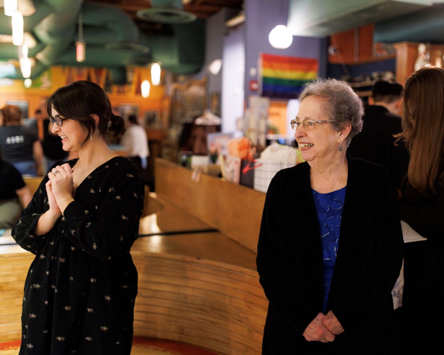 A sequence of candid shots showing people laughing and socializing at a dimly lit bar counter at Flatbreads in Somerville.