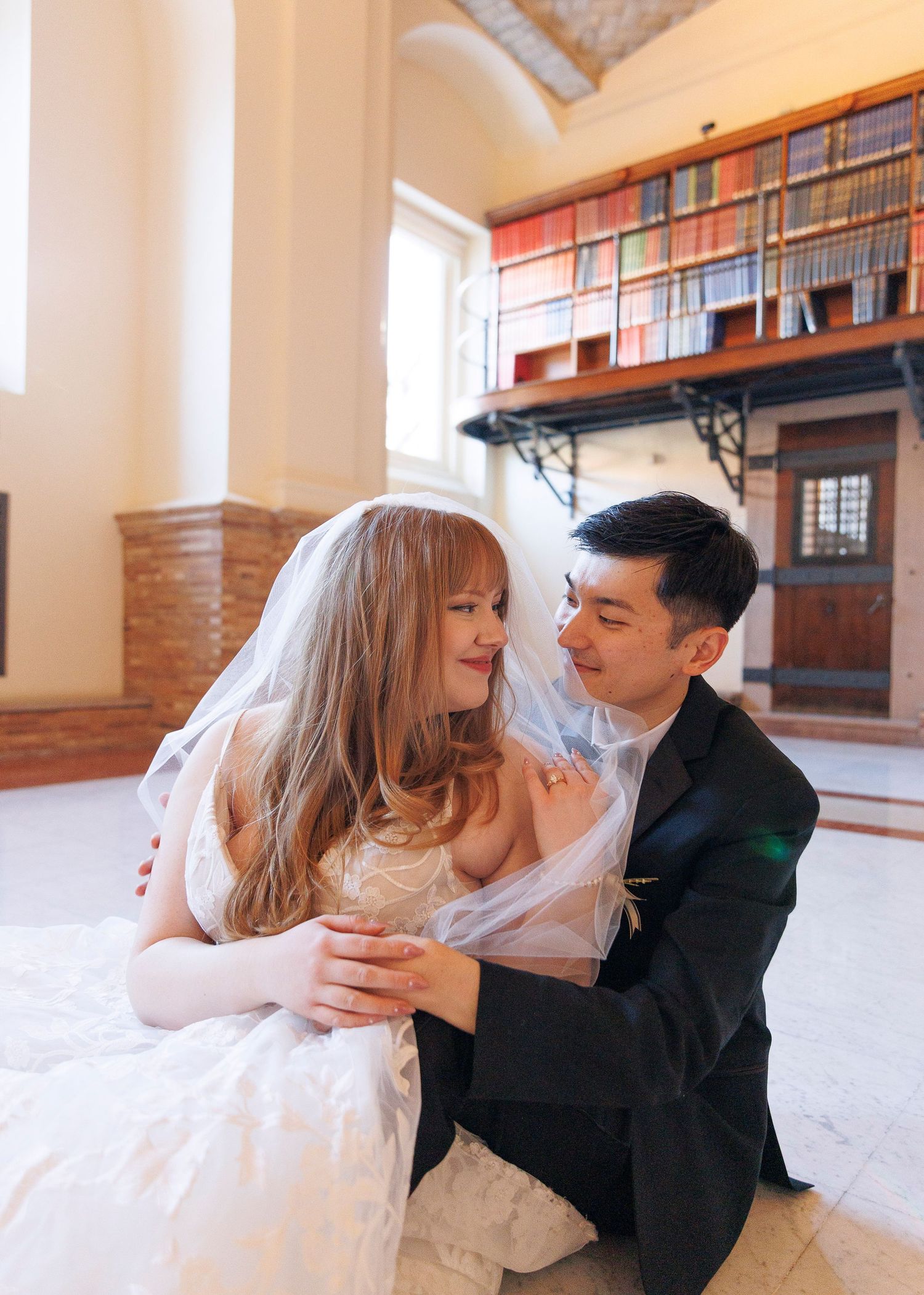 Couple looks romantically during wedding portraits of a couple tucked away in the historic book stacks of the Boston Public Library.
