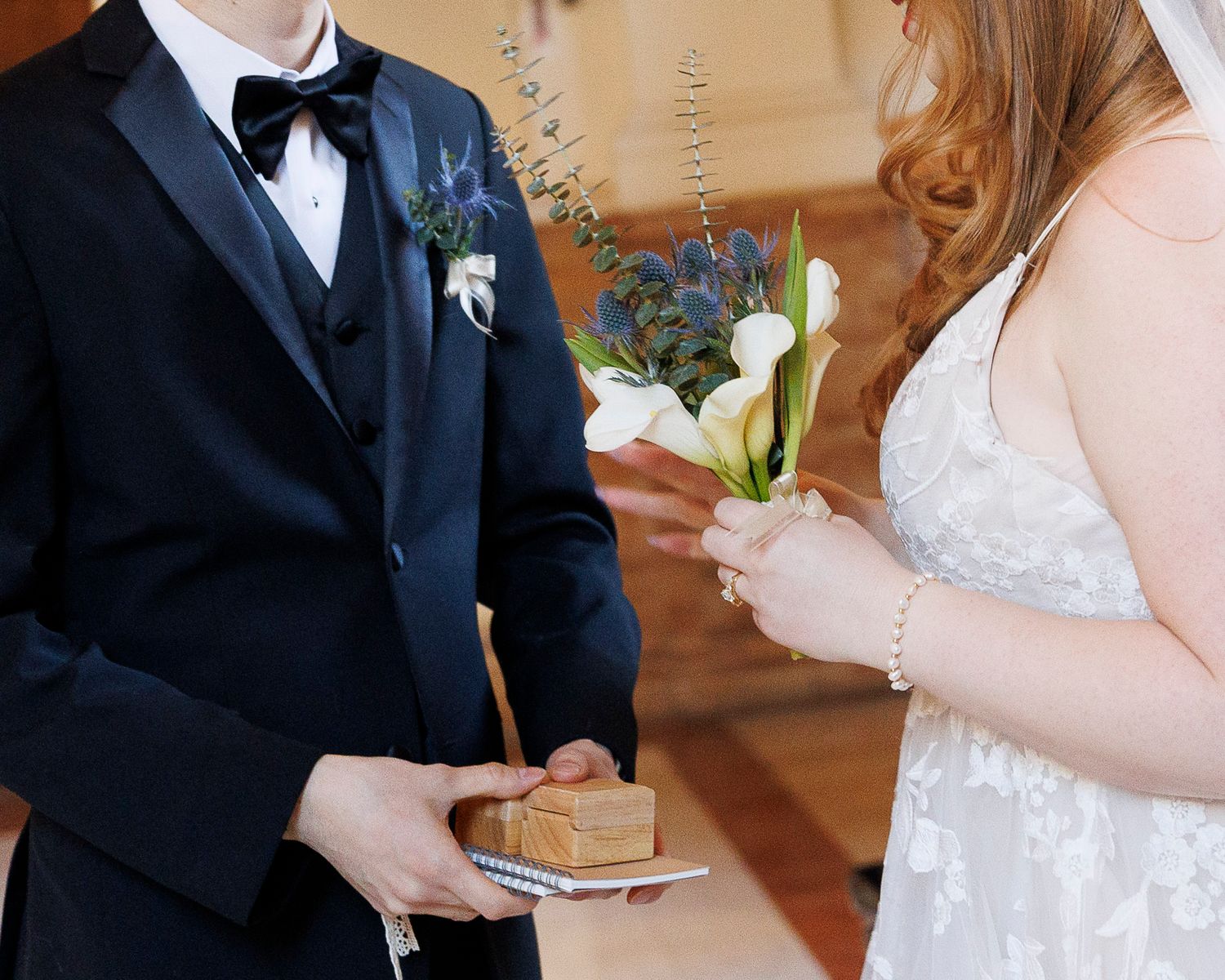 A couple in formal wedding attire signs marriage documents during their ceremony.