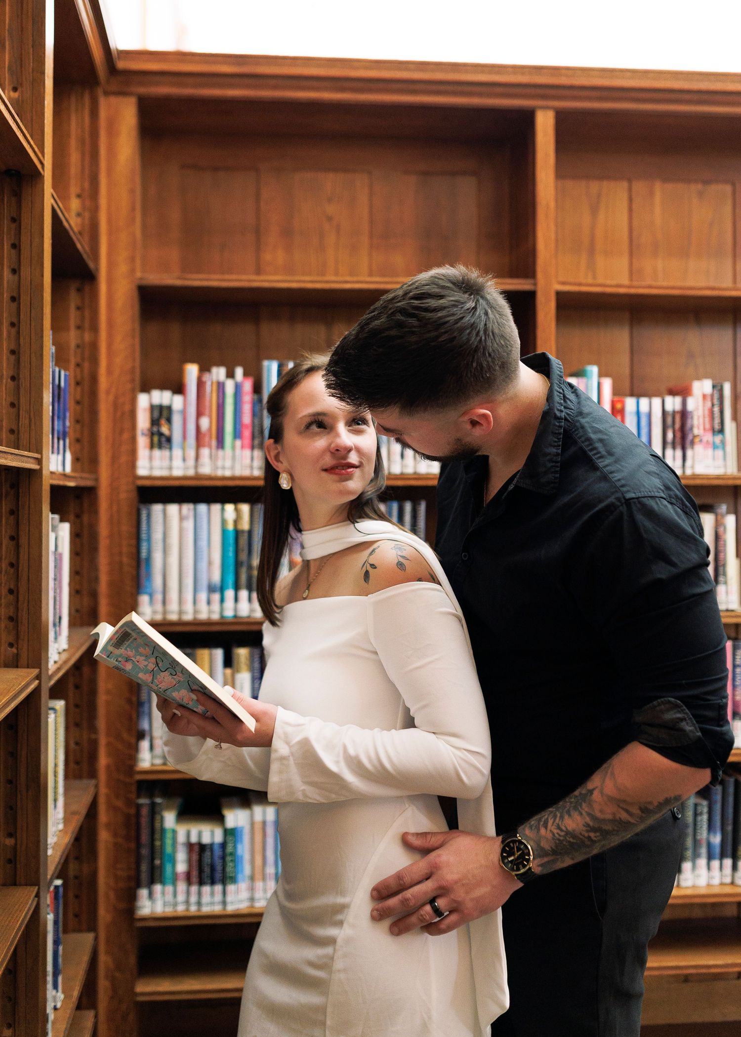 A couple dances in a wood-paneled library with bookshelves lining the walls.